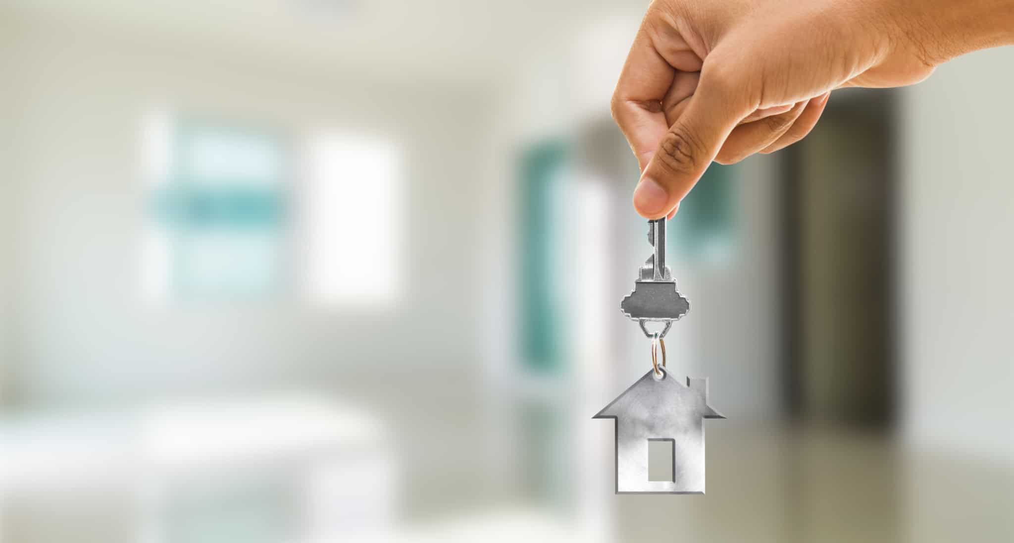 Mão a segurar um porta-chaves em forma de casa