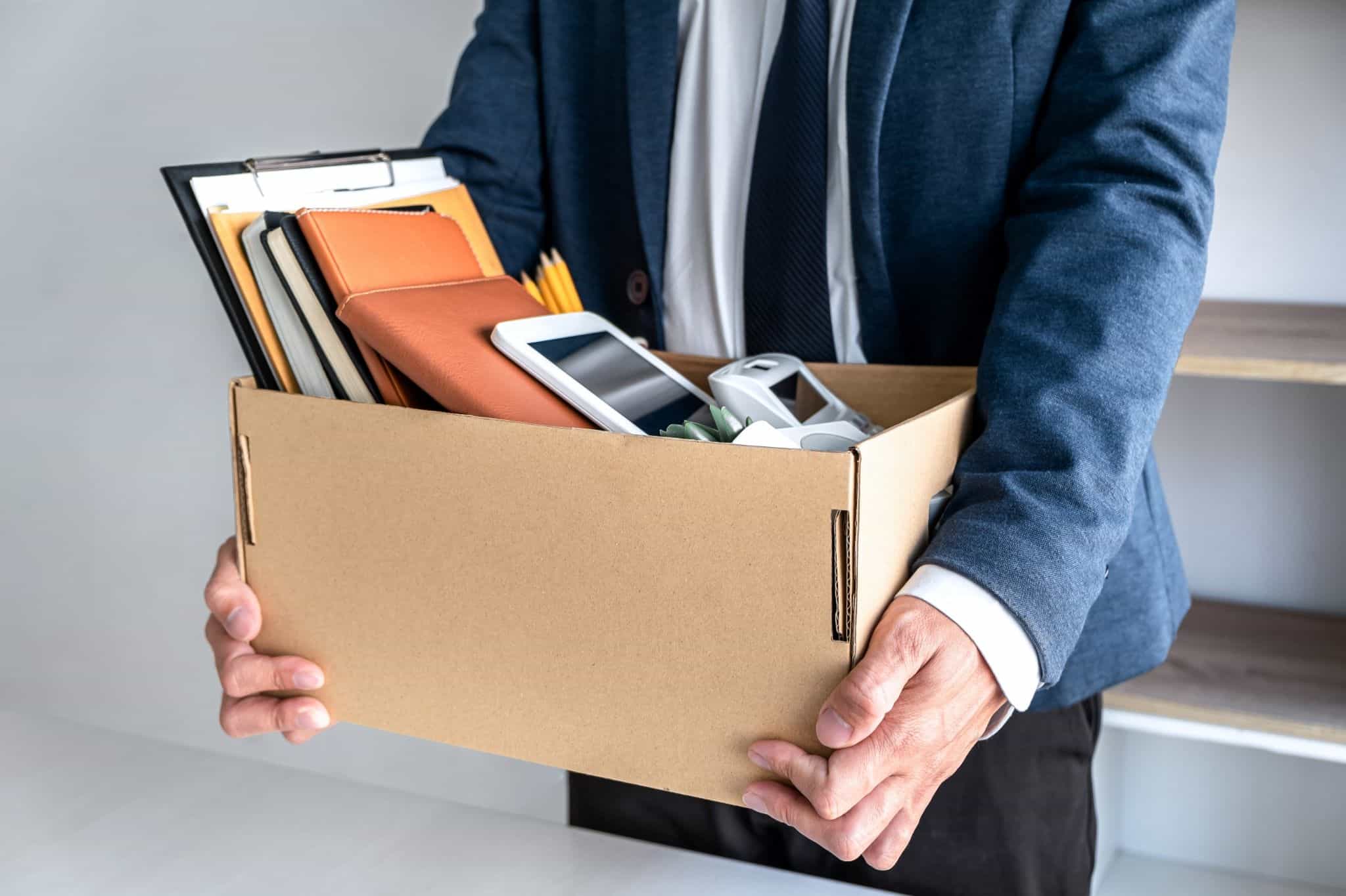 homem a segurar numa caixa com material de escritório - depois de ter ido para o desemprego