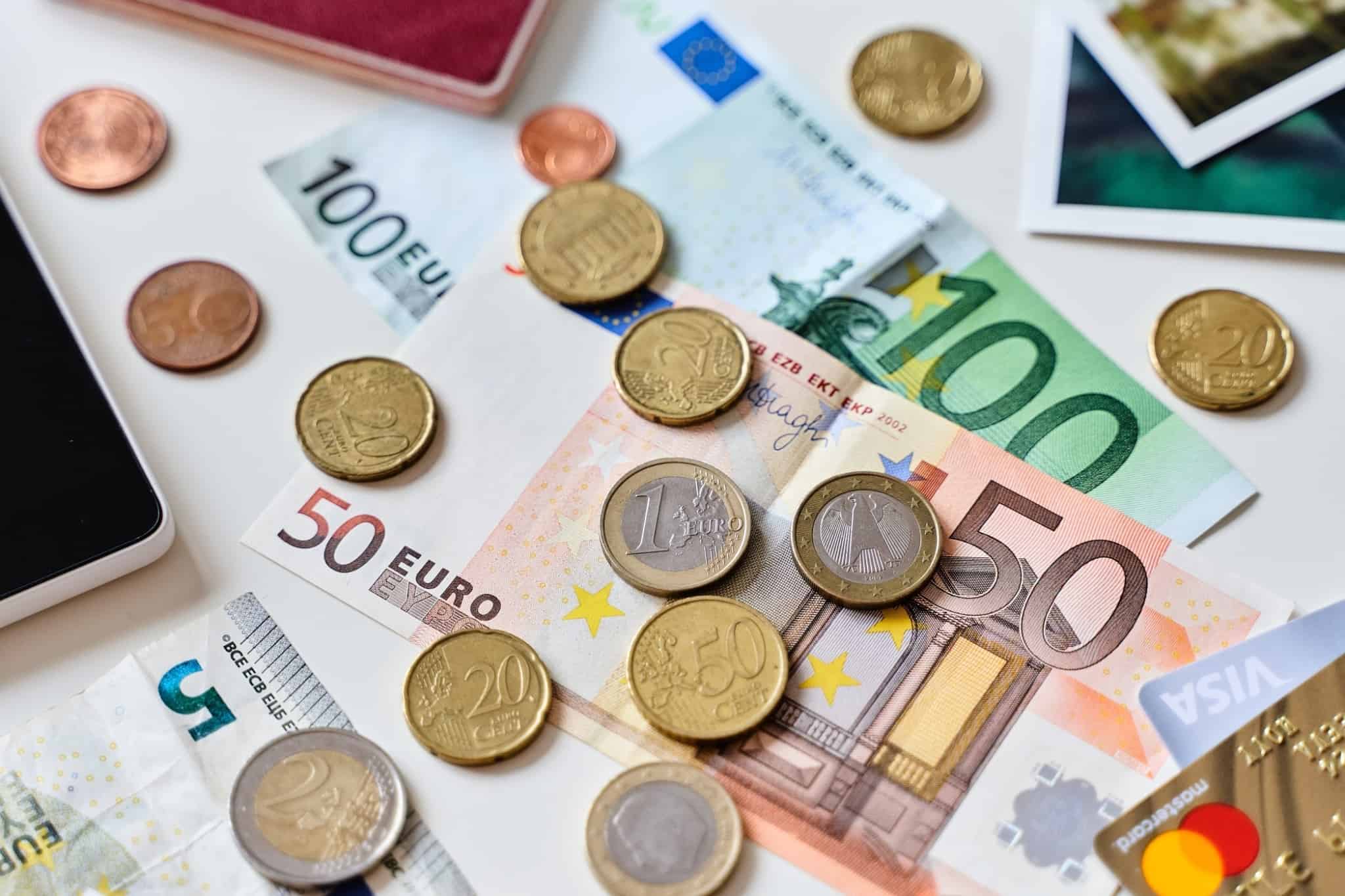 moedas e notas de euro espalhadas em cima de uma mesa