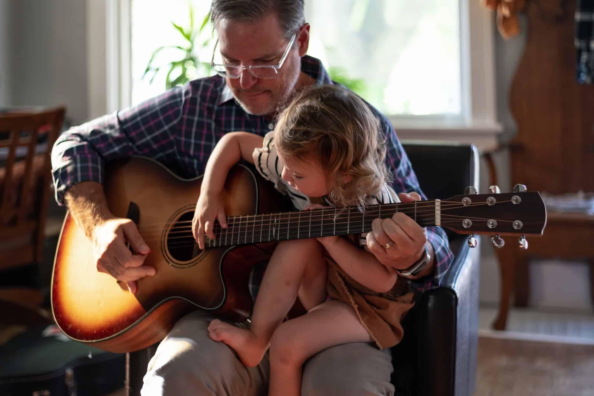 Avô ensina a neta a tocar guitarra
