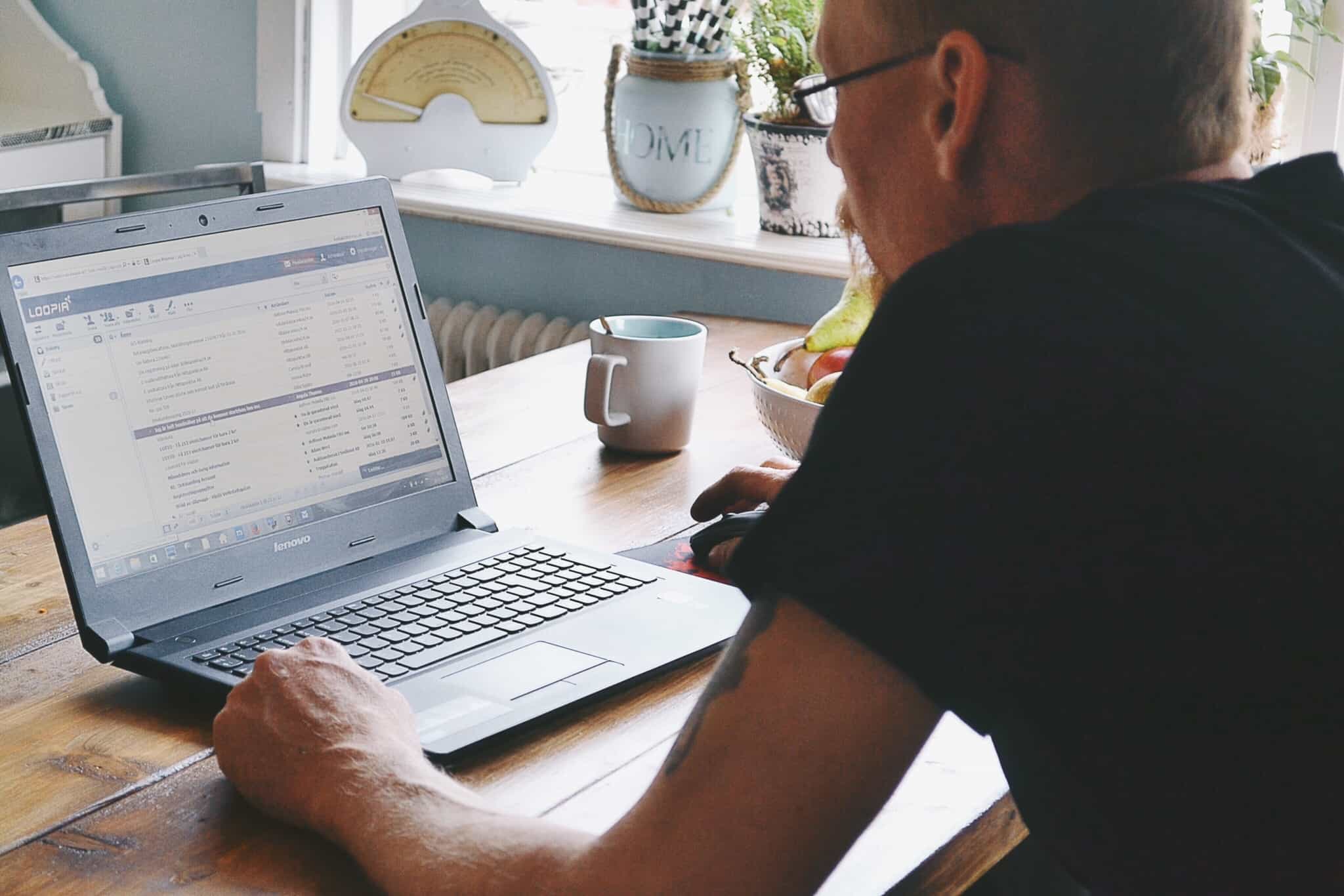 homem analisa documentos no seu computador