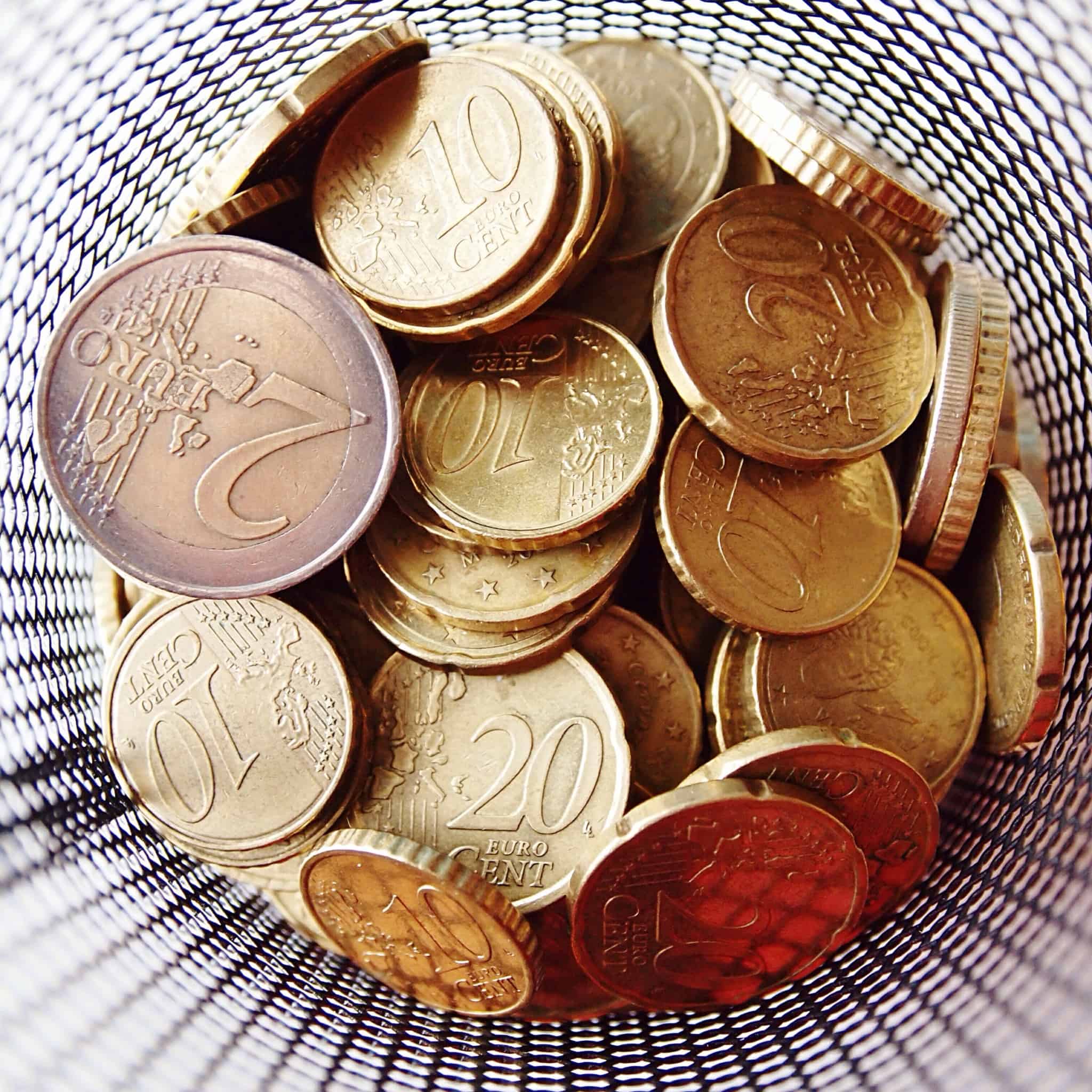 várias moedas de euro dentro de um copo