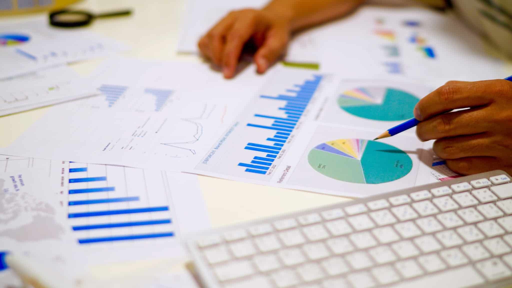 Mulher analisa vários gráficos co informação financeira de uma empresa