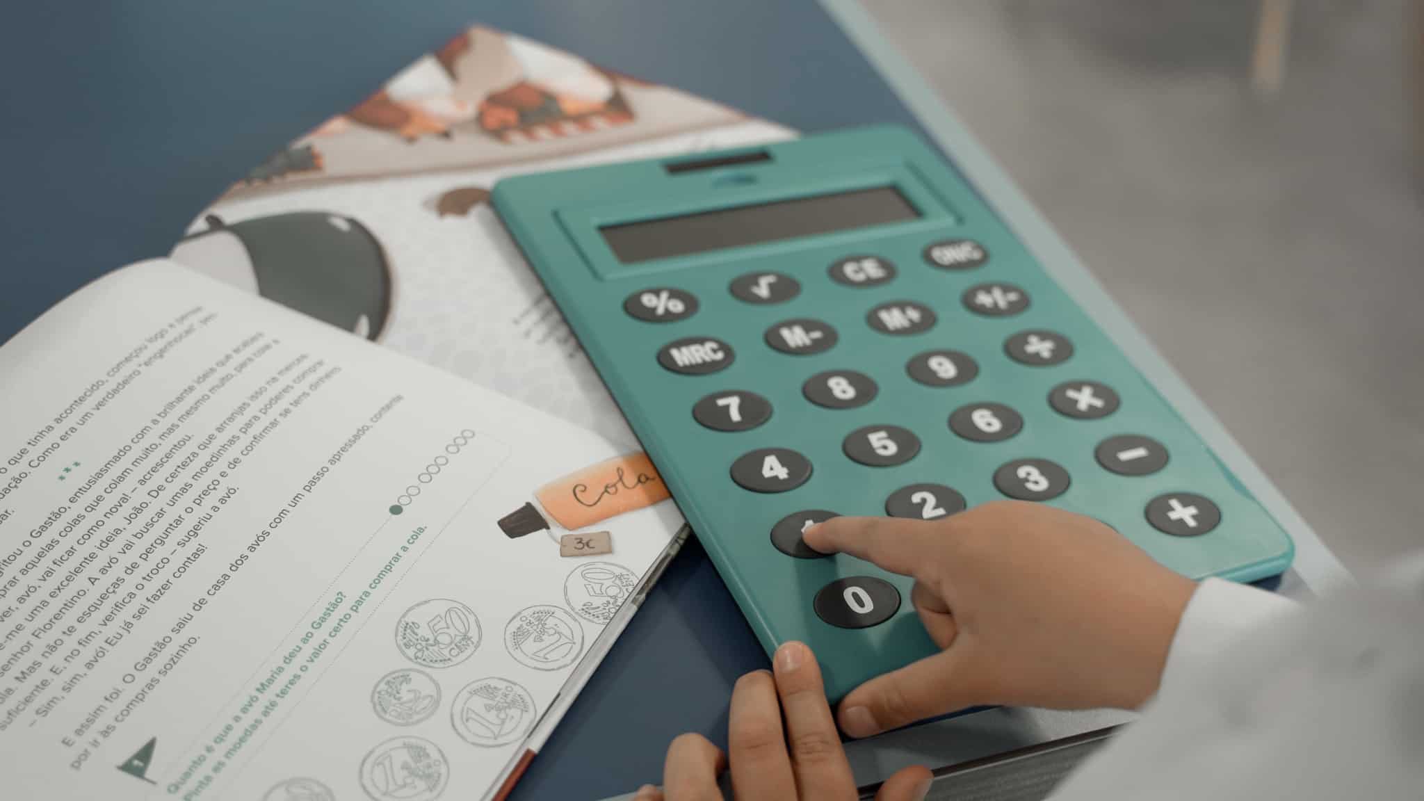 Imagem do livro infantil do Doutor Finanças e de uma criança a usar uma calculadora gigante
