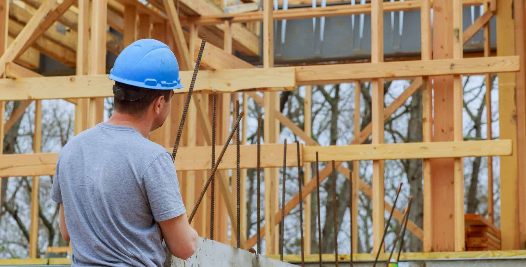 homem a construir uma habitação
