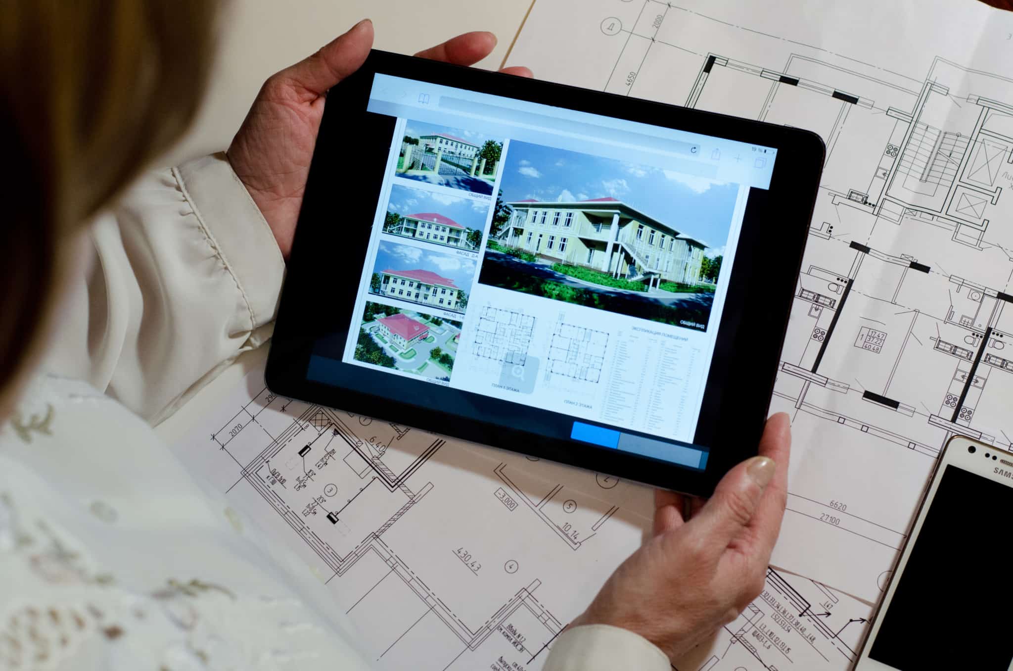 Mulher visualiza uma planta de casa através de um tablet