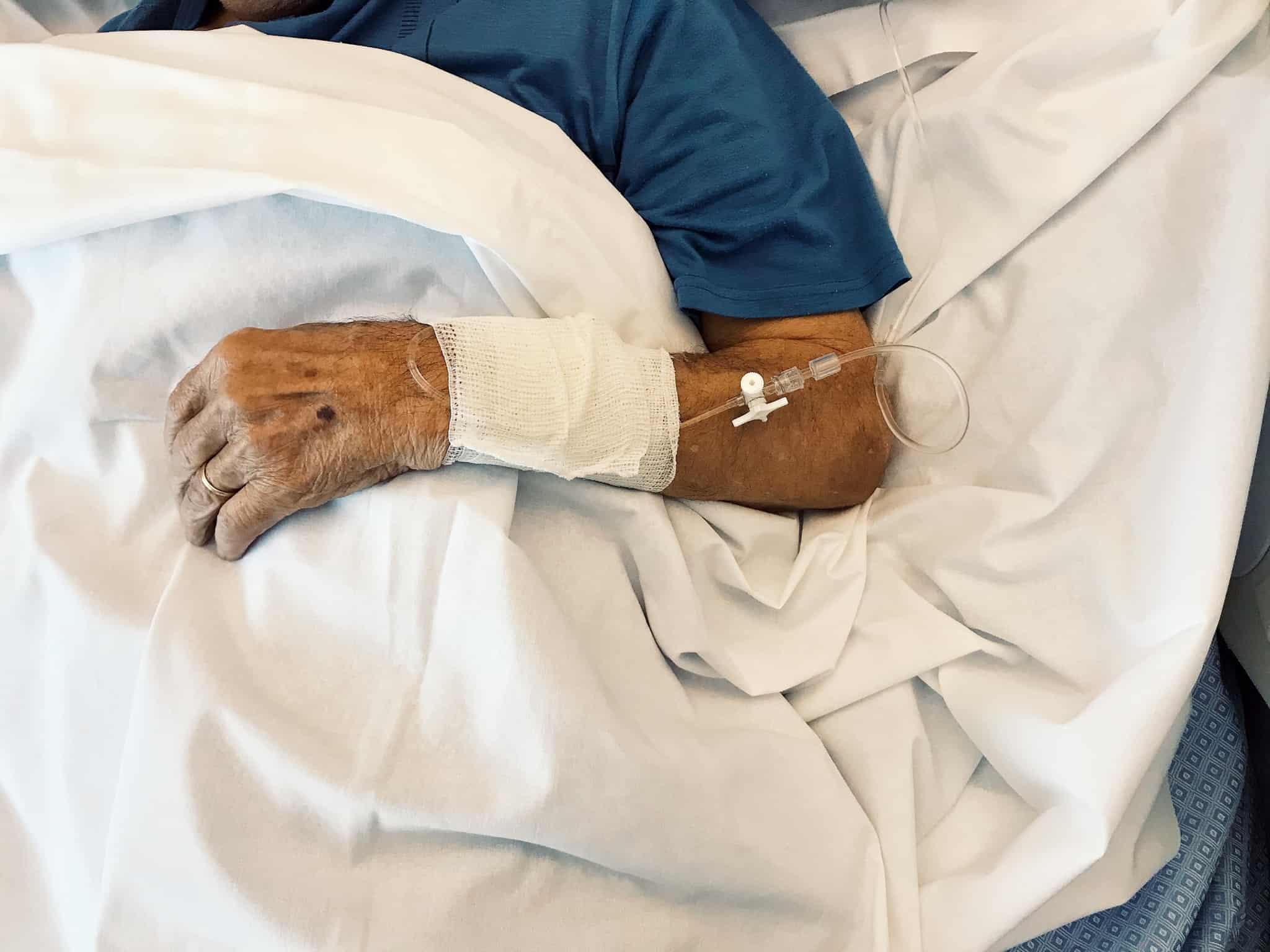 Homem idoso deitado numa cama de hospital