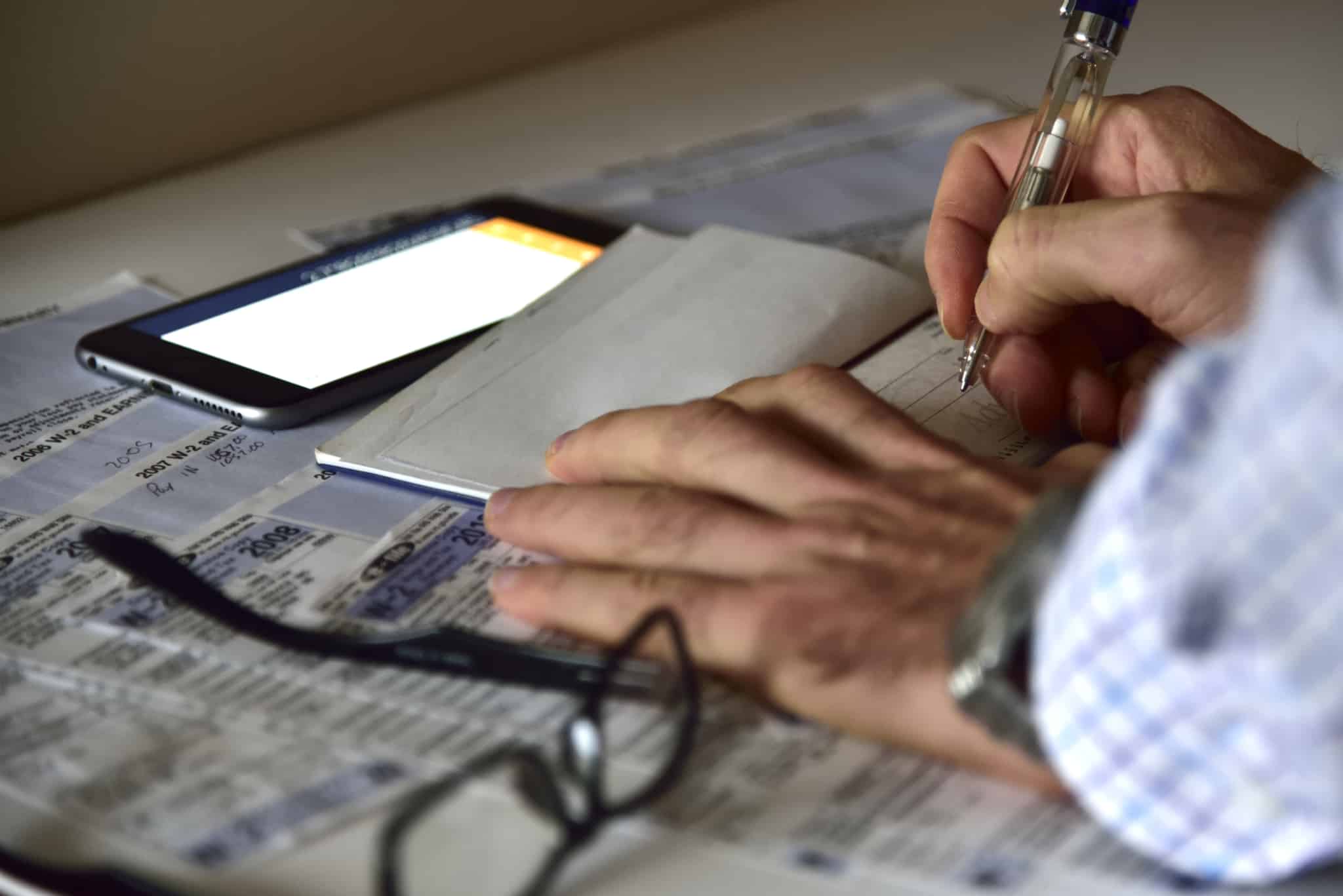 homem, a trabalhar sobre uma mesa de escritório, a aprender como preencher um cheque
