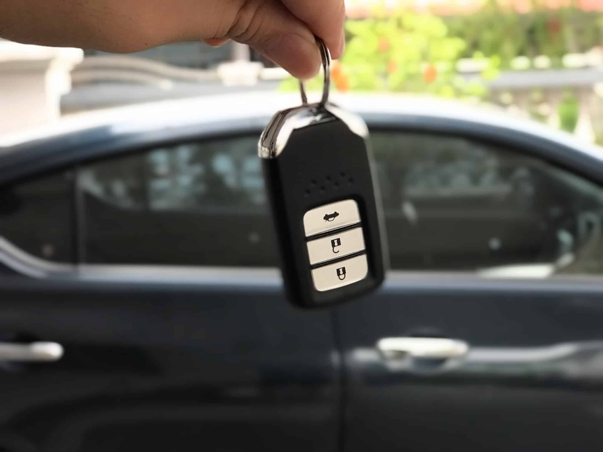Chave de um carro novo na mão do um cliente que acabou de comprar o carro