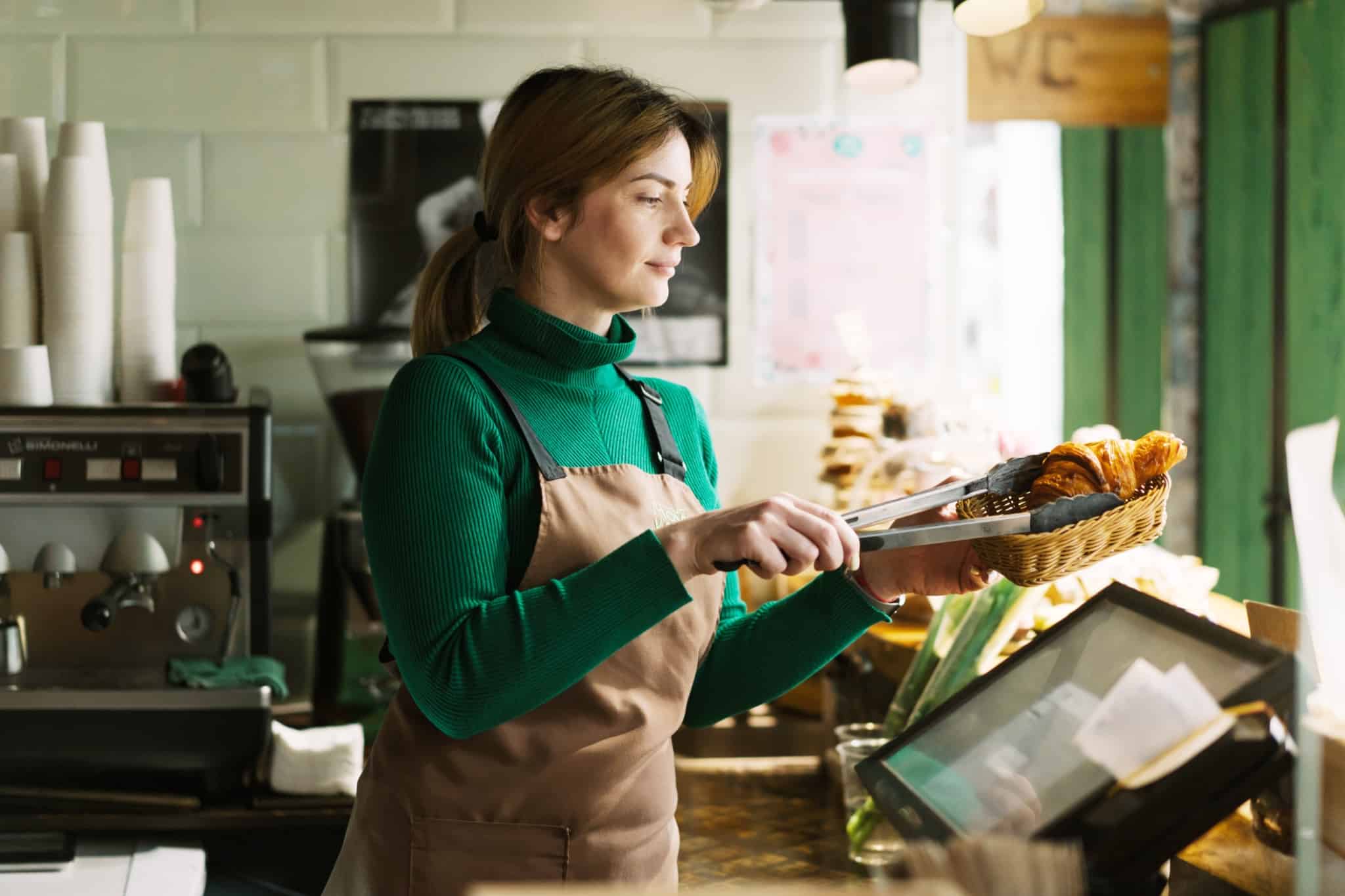 jovem mulher a trabalhar num cafe, um emprego que é uma oportunidade de verão para os jovens