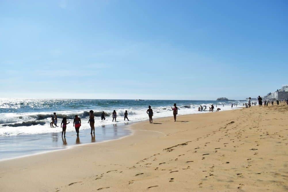 várias pessoas na praia à beira mar