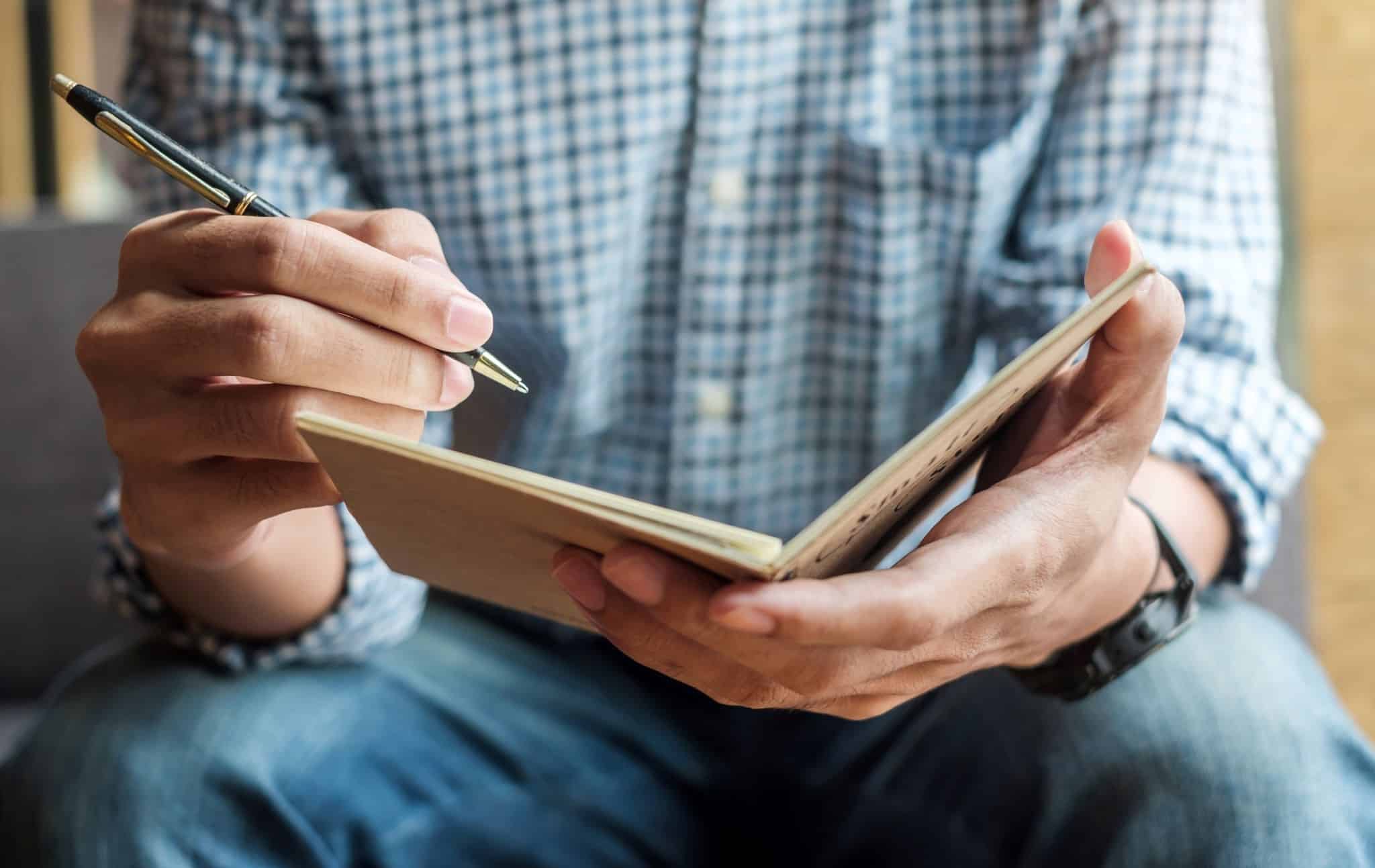Trono de homem com caderno e caneta a evocar as componentes do salário