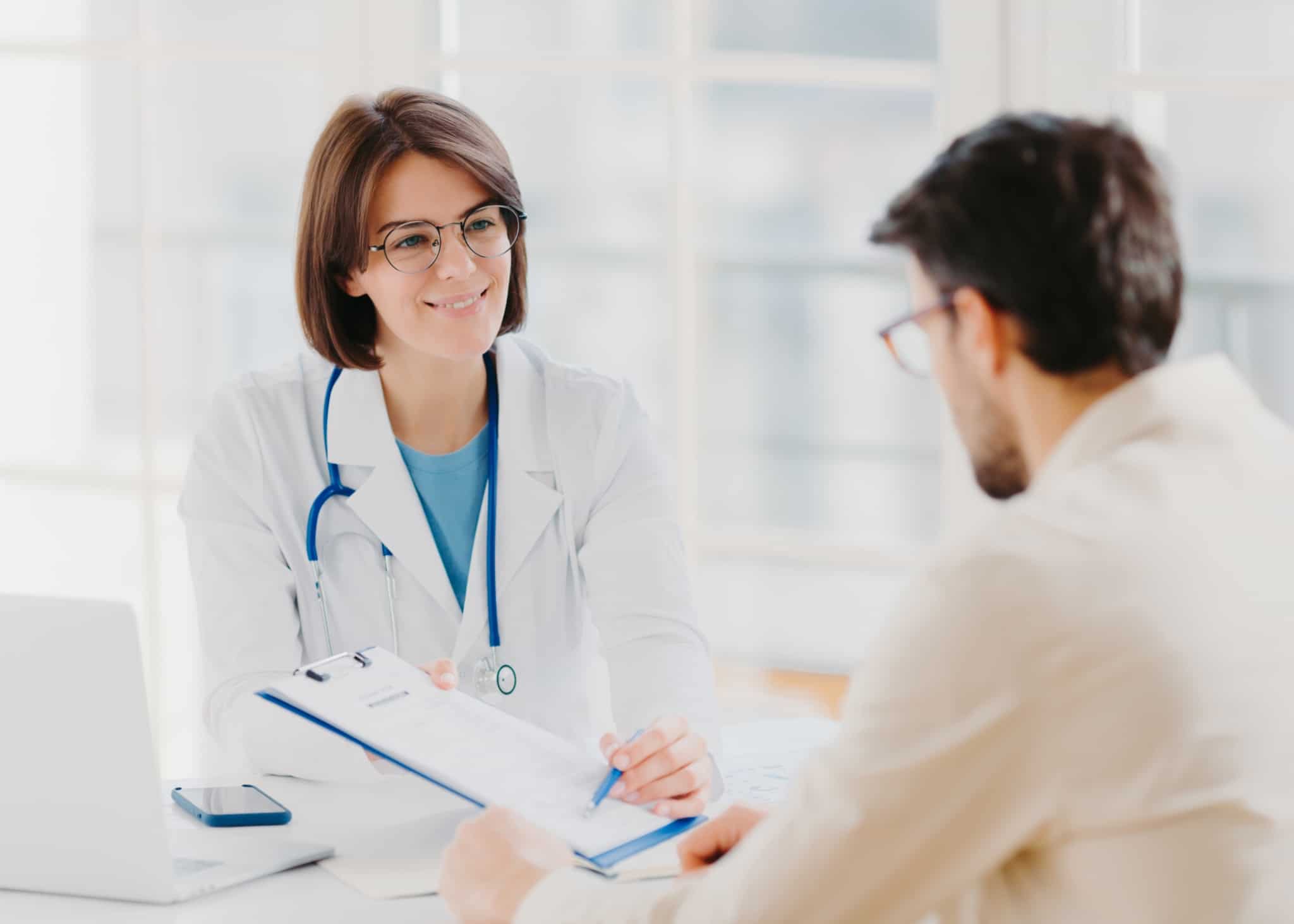 médica de família recbe o seu paciente no gabinete