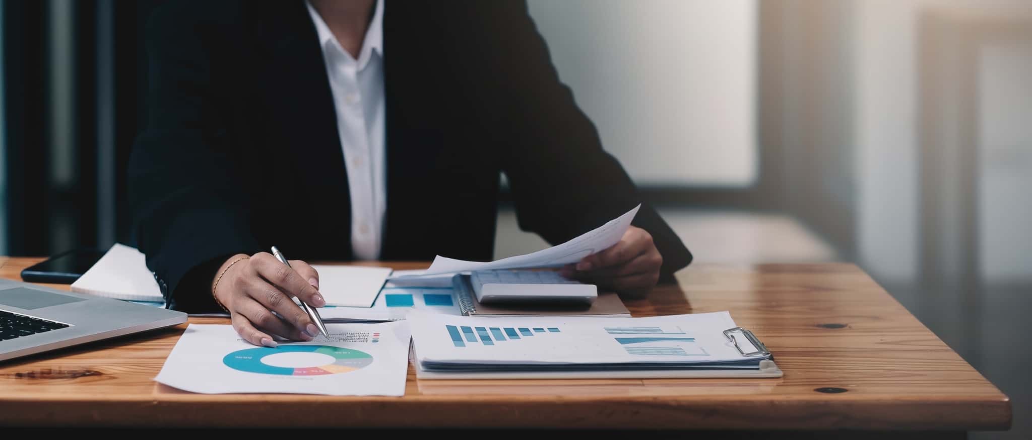 homem, sentado à mesa do escritório, analisa documentos e estuda a sua eficiência fiscal, enquanto trabalhador independente