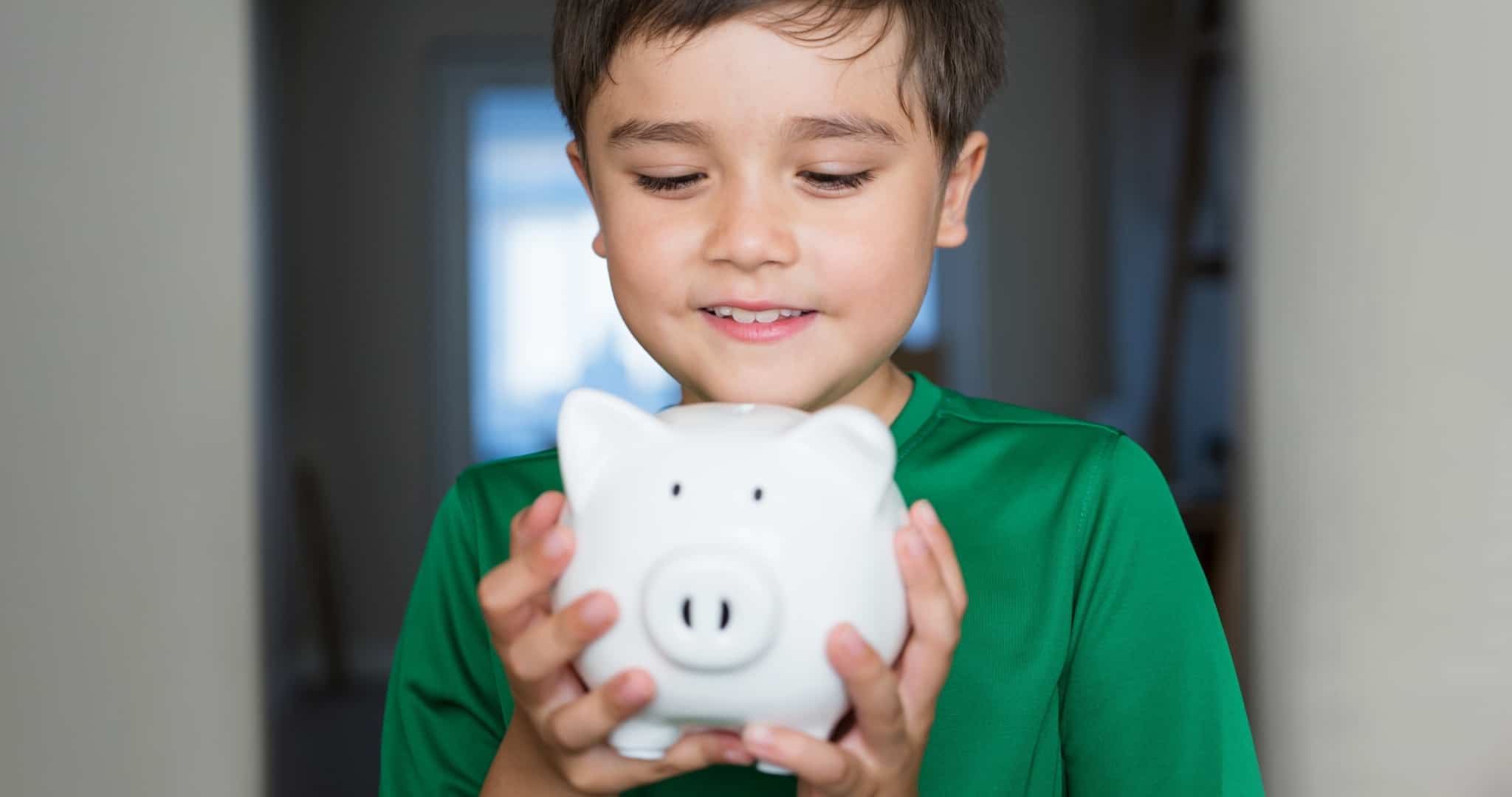Criança com porquinho mealheiro nas mãos a aprender decisões financeiras