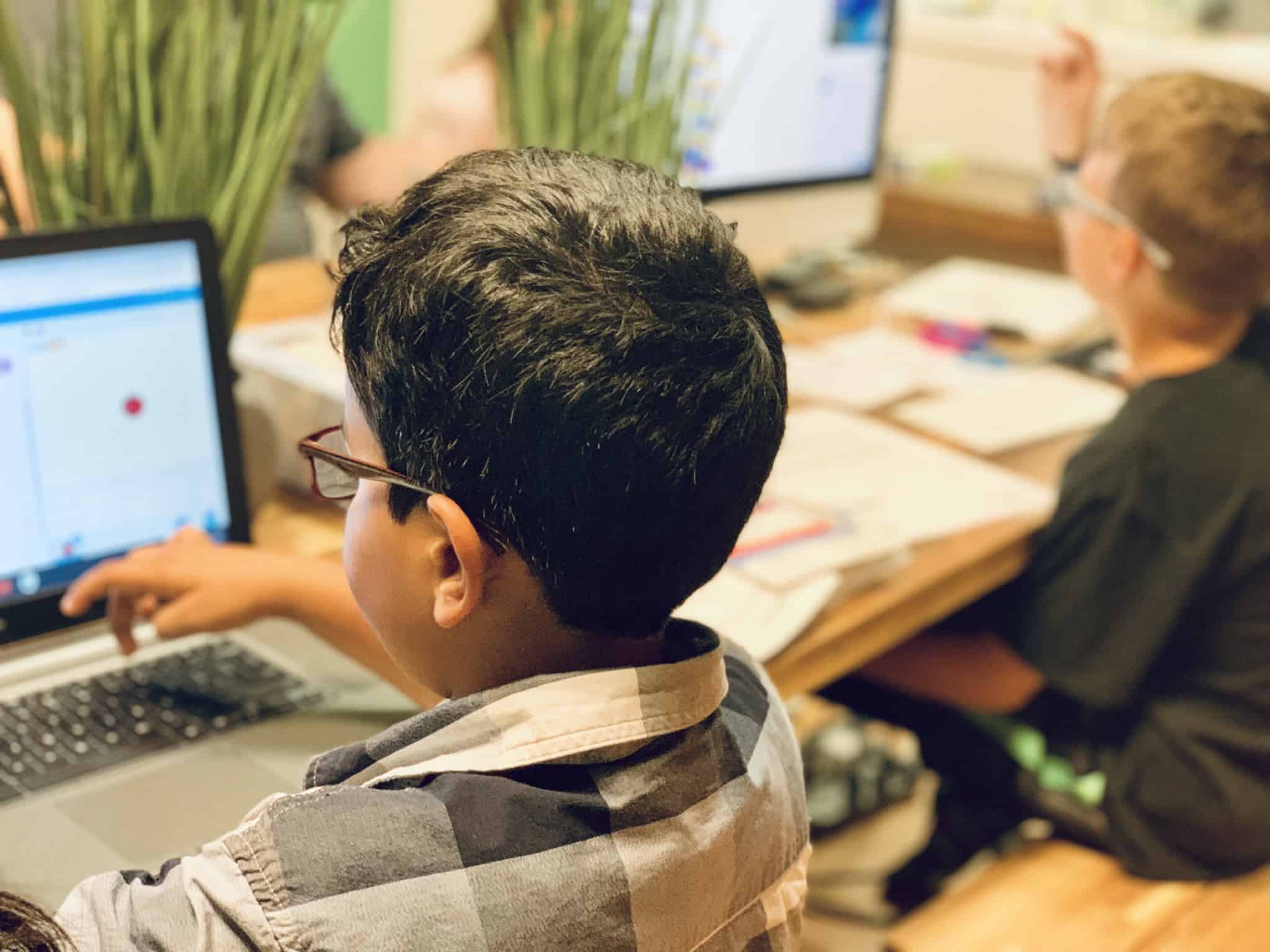 duas crianças, dois rapazes, na escola a lidar com o computador