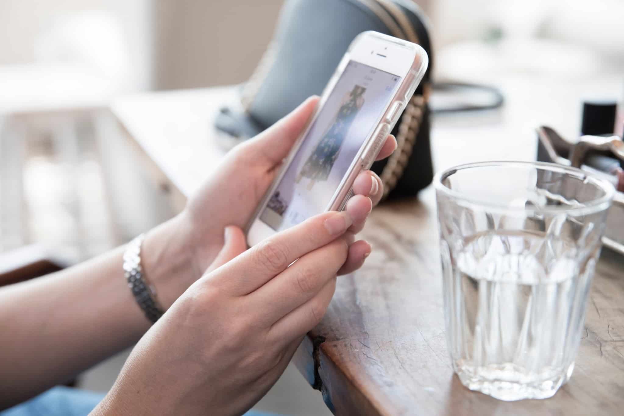 Imagem de uma mulher a fazer compras no smartphone - compras por impulso