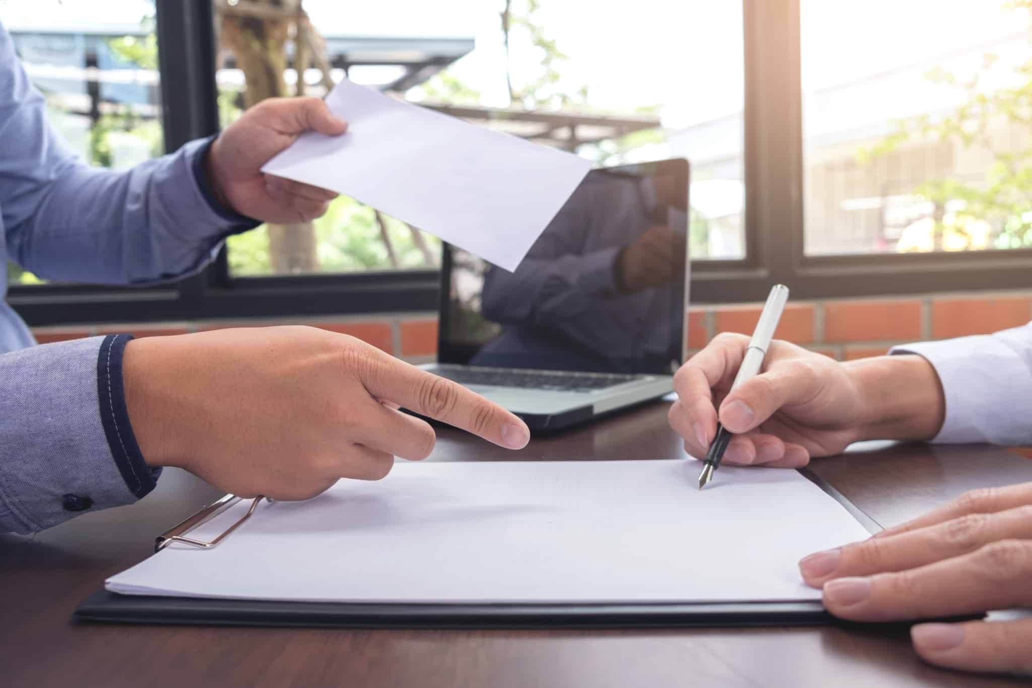 pessoa a assinar a carta de apresentação para primeiro emprego