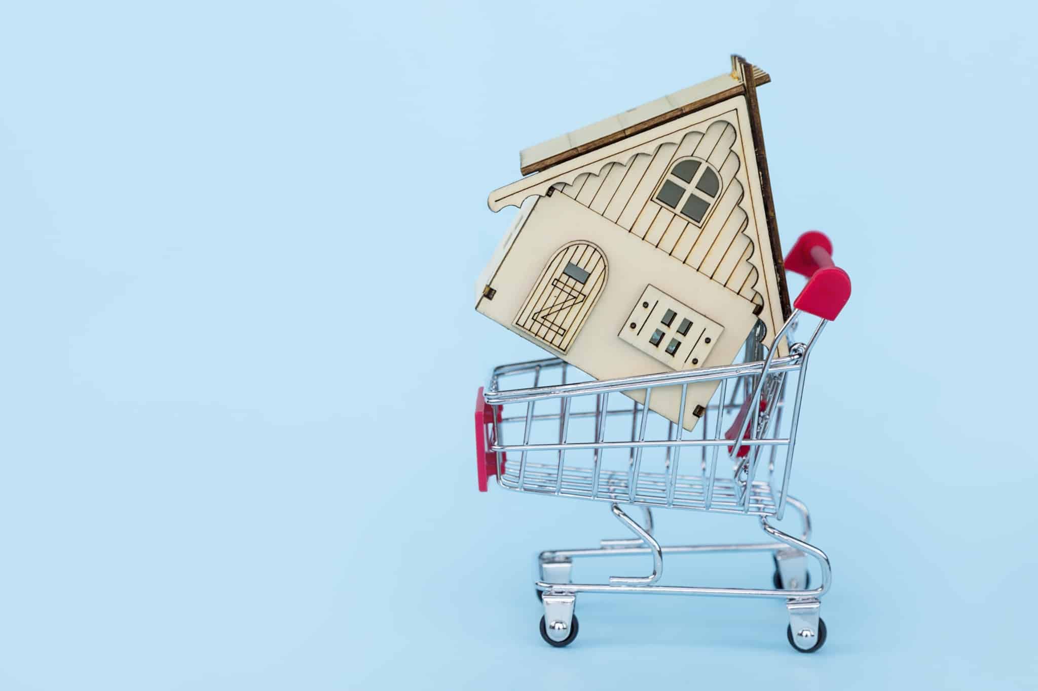 vender casa sozinho ilustrado por produção fotográfica com uma casa num carrinho de supermercado