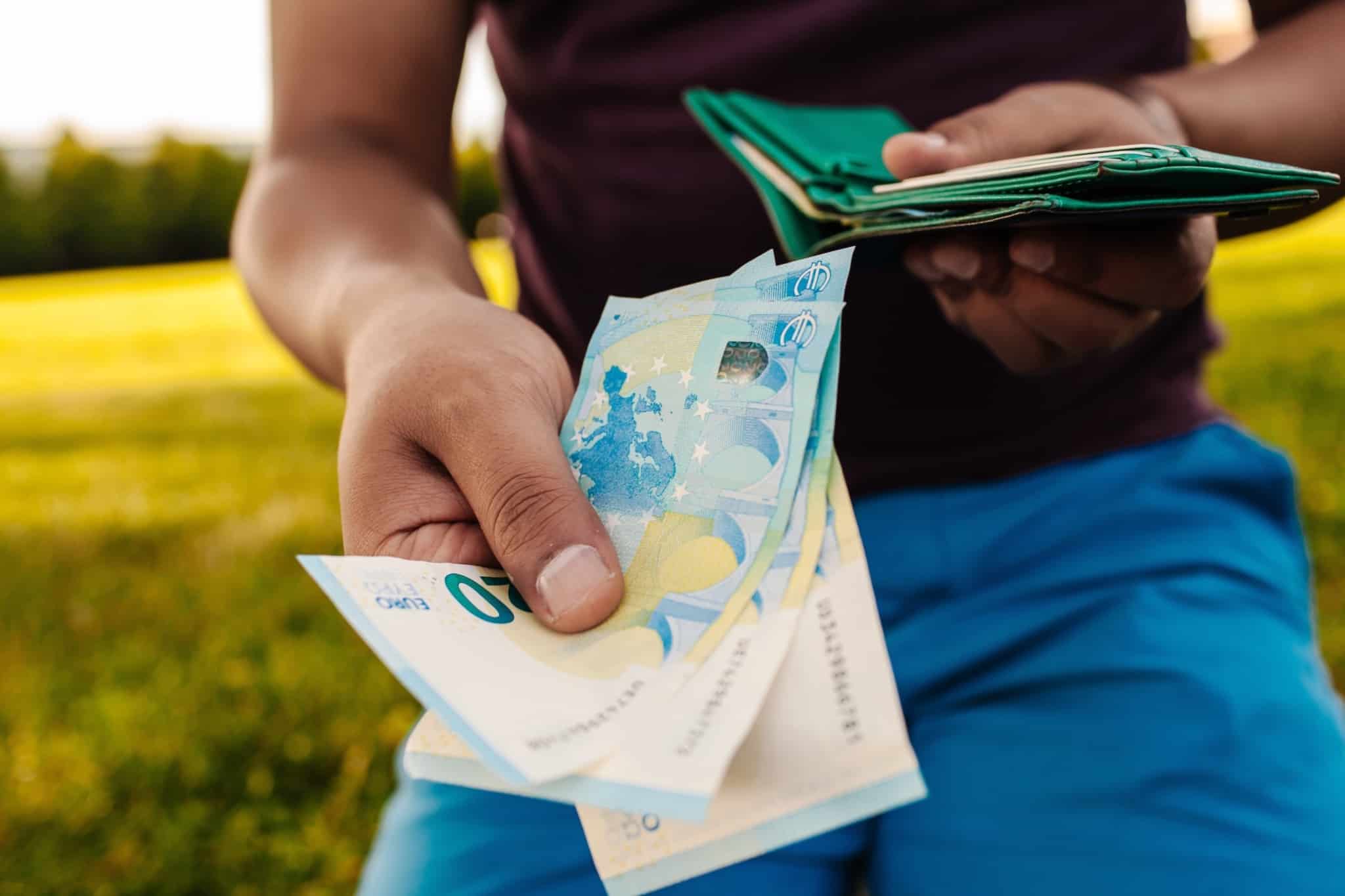 Homem oferece notas de 20 euros, numa alusão ao aumento do salário devido às tabelas de retenção na fonte