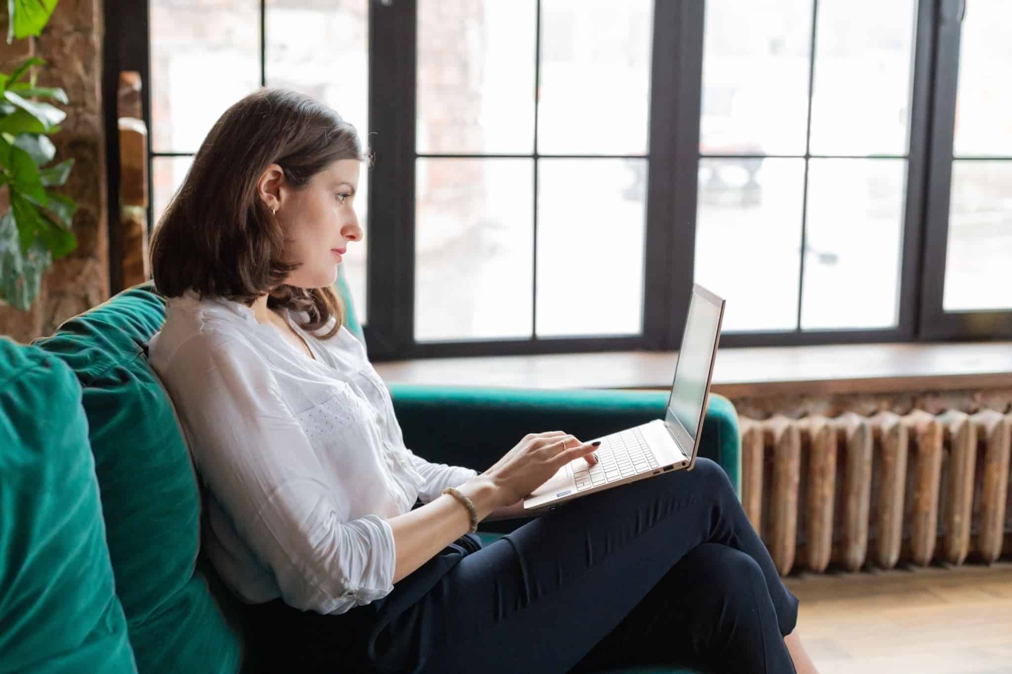 jovem mulher, trabalhadora independente, pesquisa no computador a que subsídios tem direito em situação de desemprego ou perda de parte do rendimento.