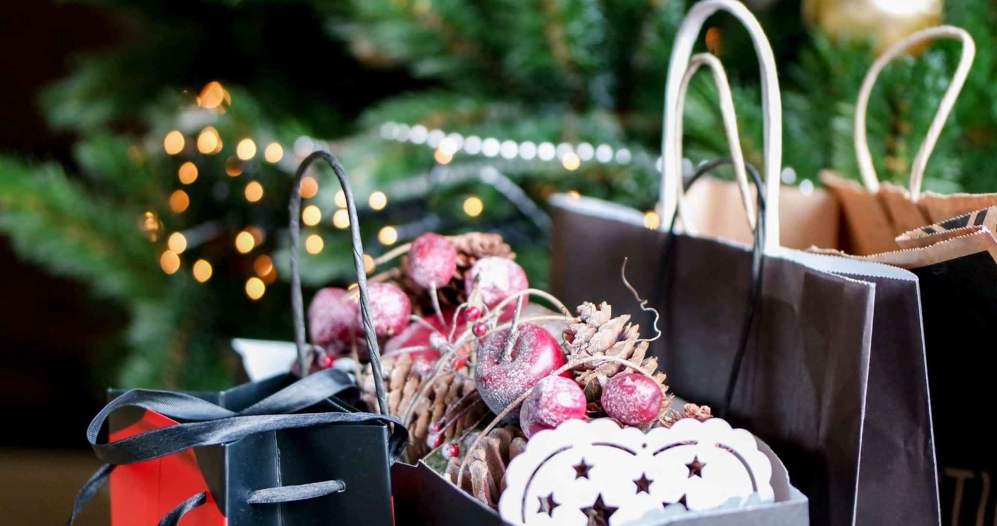 Sacos com prendas de Natal à frente de uma árvore de Natal