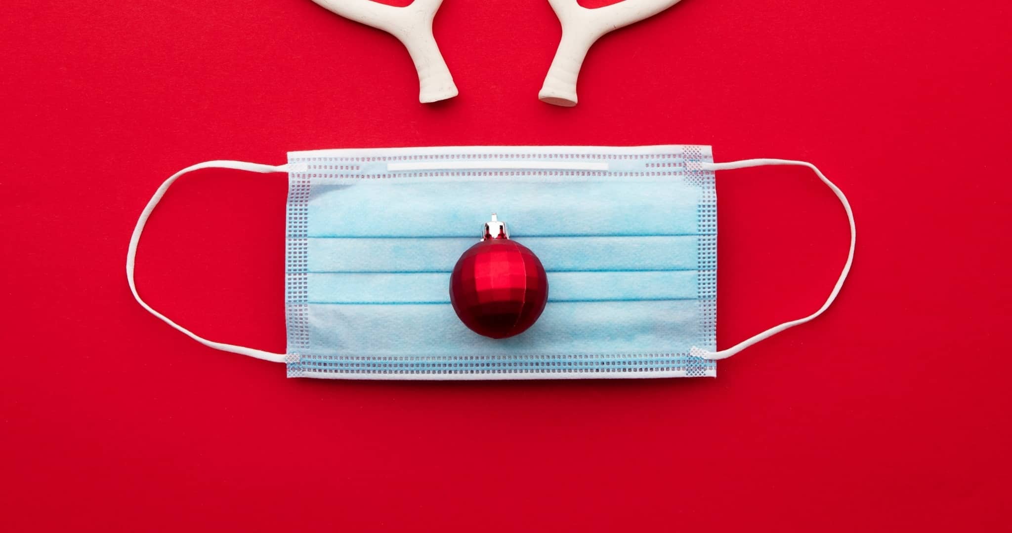 Máscara pandemia com bola de árvore de Natal a fazer de nariz e hastes de rena por cima
