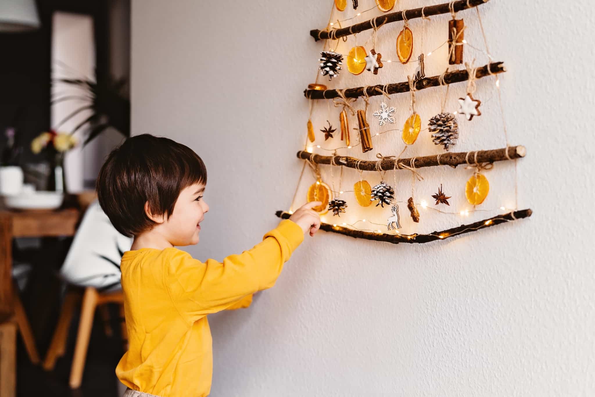 menino brinca coma asua árvores de Natal , construída de forma sustentável, oroginal, só com peças feitas à mão
