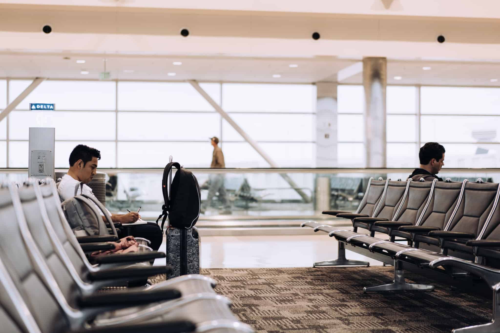 homem à espera no aeroporto para começar um emprego no estrangeiro