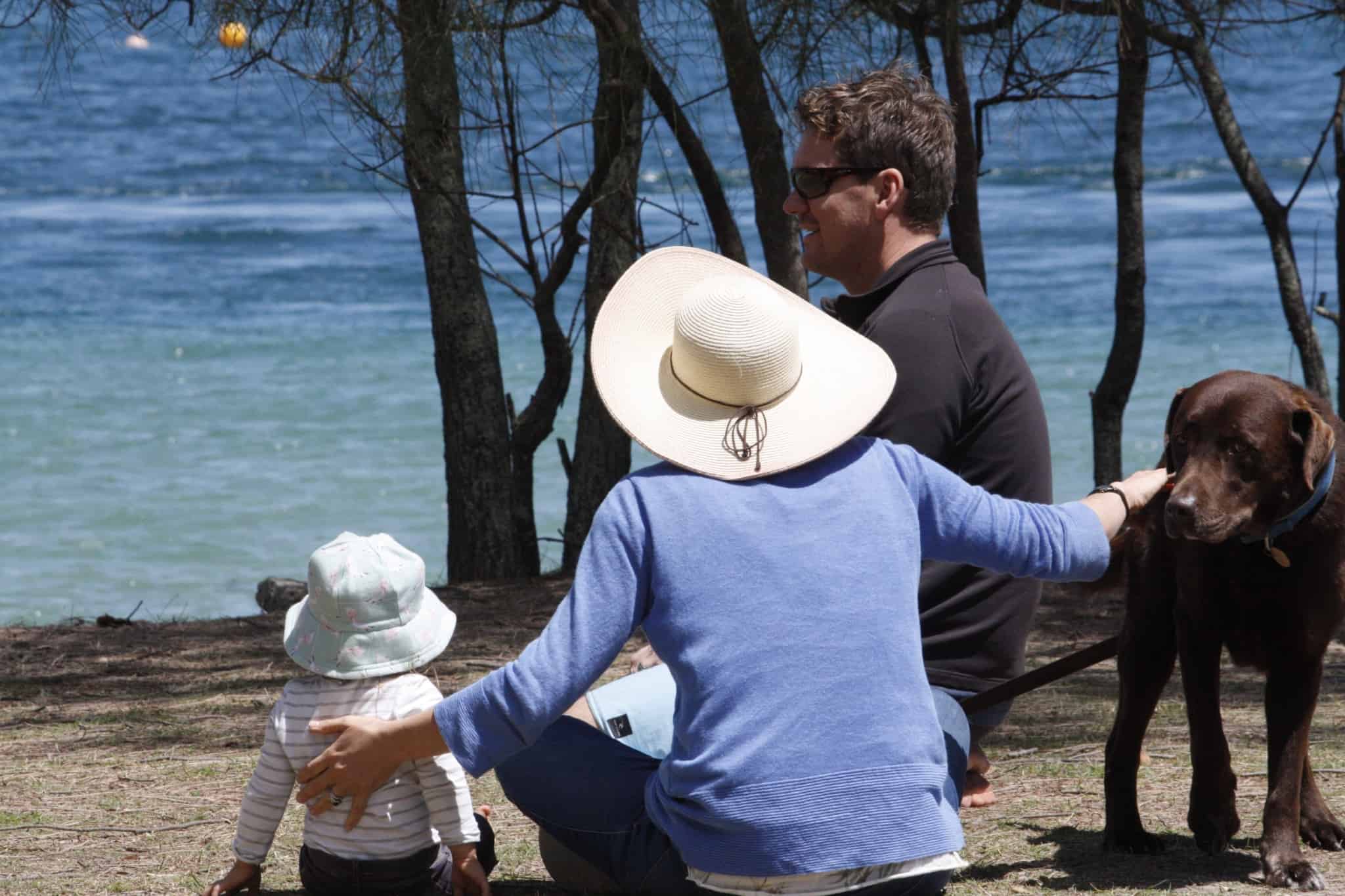 pai, mãe, bébe e cão, usufruem da natureza, junto ao mar