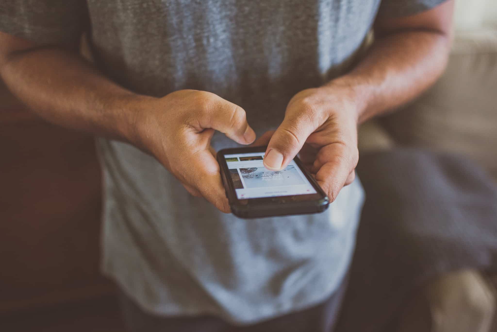 jovem consulta app no telemóvel, para o cartão e-fatura com o número de contribuinte