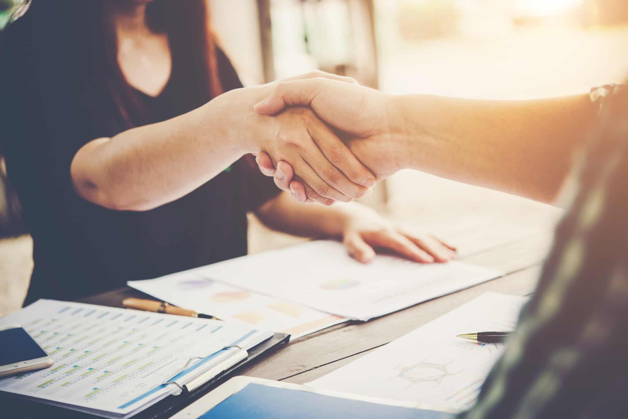 homem e mulher dão um aperto de mão para selar o incío do contrato de trabalho