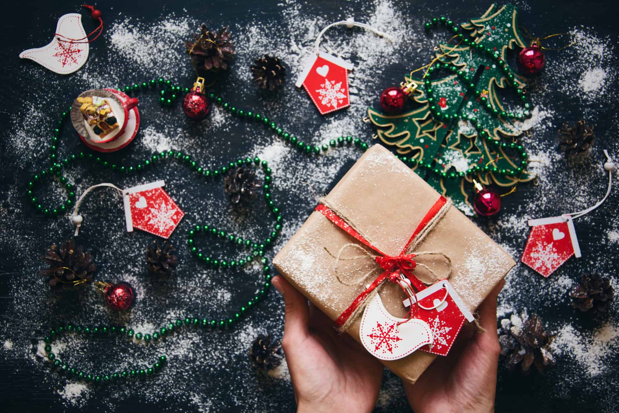 Presente de Natal embrulhado e rodeado de icons natalícios