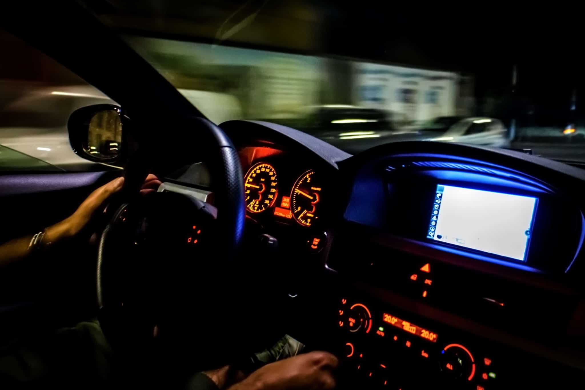 Pessoa conduz um automóvel à noite