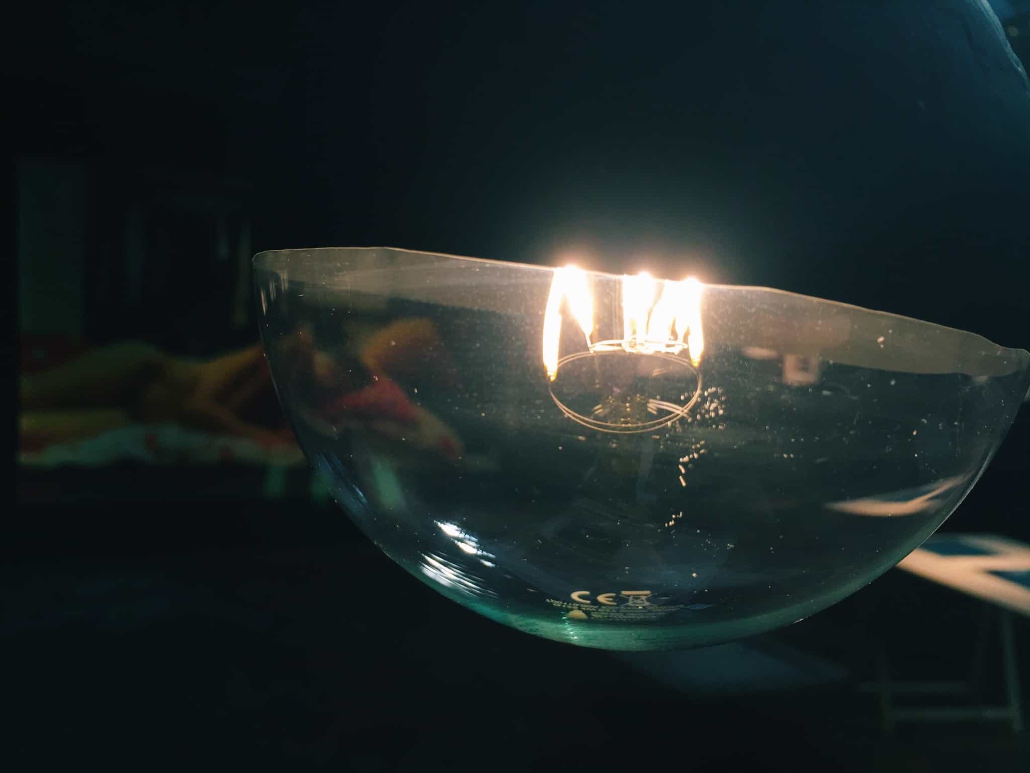 zoom ao ainterior de uma lampada, que ilumina pouco num fundo escuro