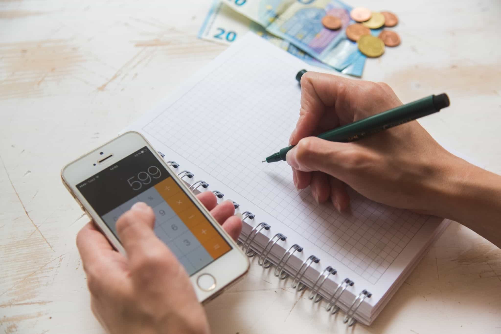 Imagem de alguém com uma calculadora no telemóvel e um caderno - juros moratórios