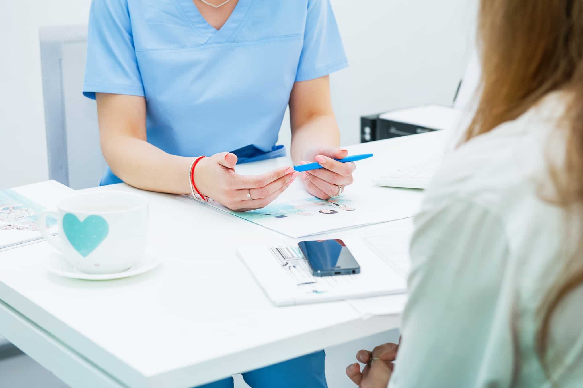 consulta médica, entre duas jovens mulheres, com explicação de resultados de testes dada pela médica à paciente