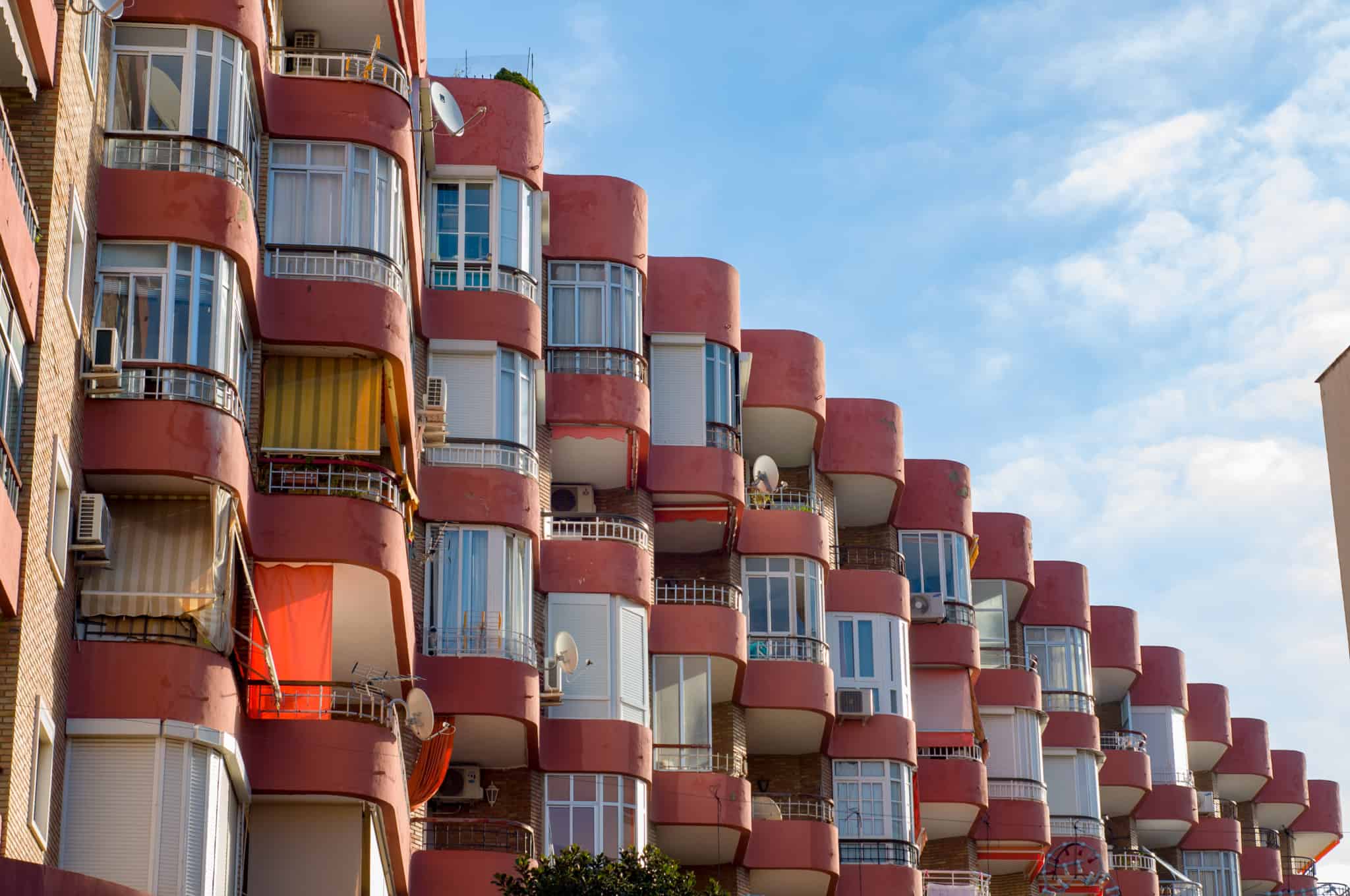 fachada de edifícios cor de rosa, de muitos andares, com pequenas marquises, ilustrando a obrigatoriedade de existir um regulamento do condomínio