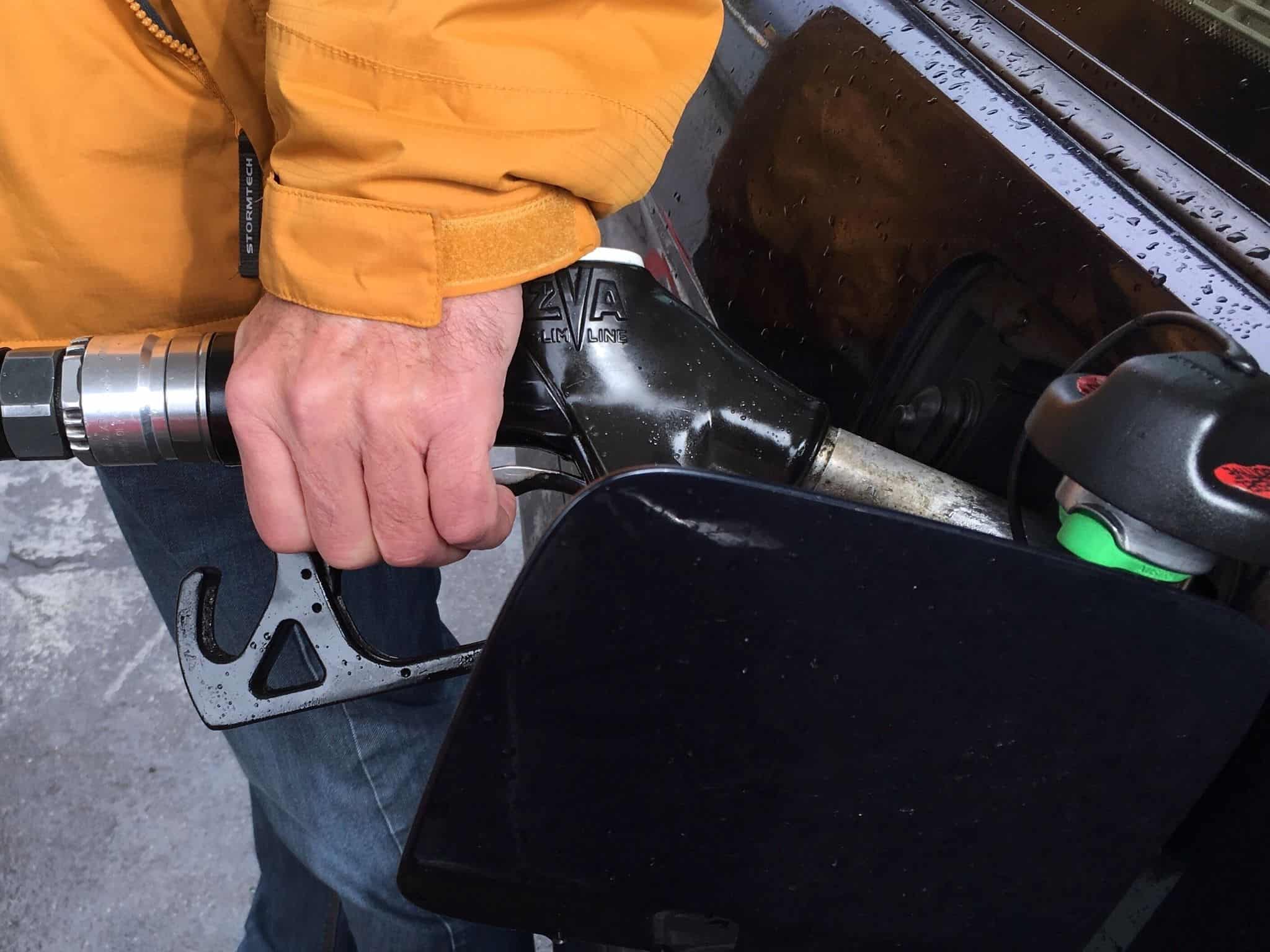 Homem agarra na mangueira para abstecer o carro, tentando poupar combustível