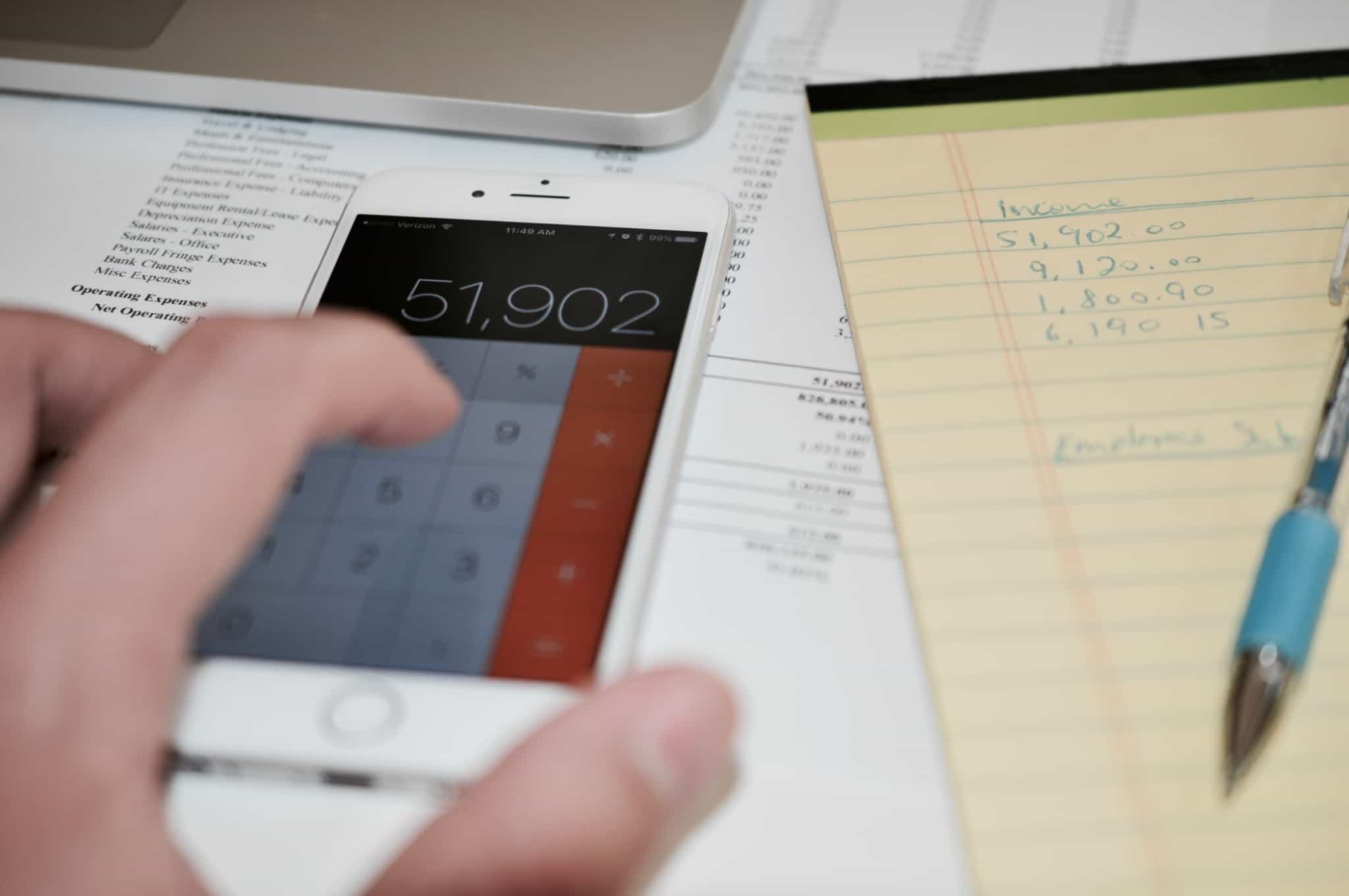 Imagem de alguém a usar a calculadora do telemóvel - contas para reduzir créditos
