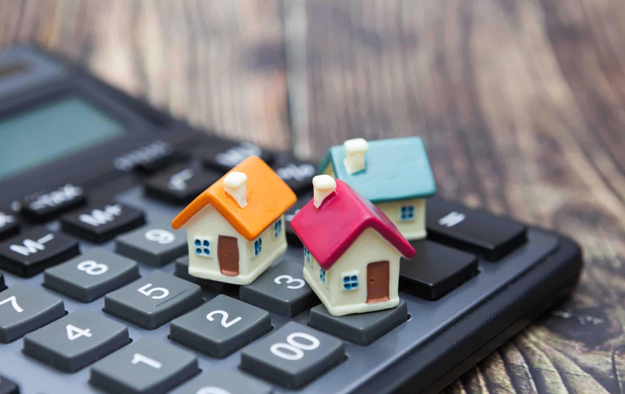 três casas pequenas em cima de uma calculadora