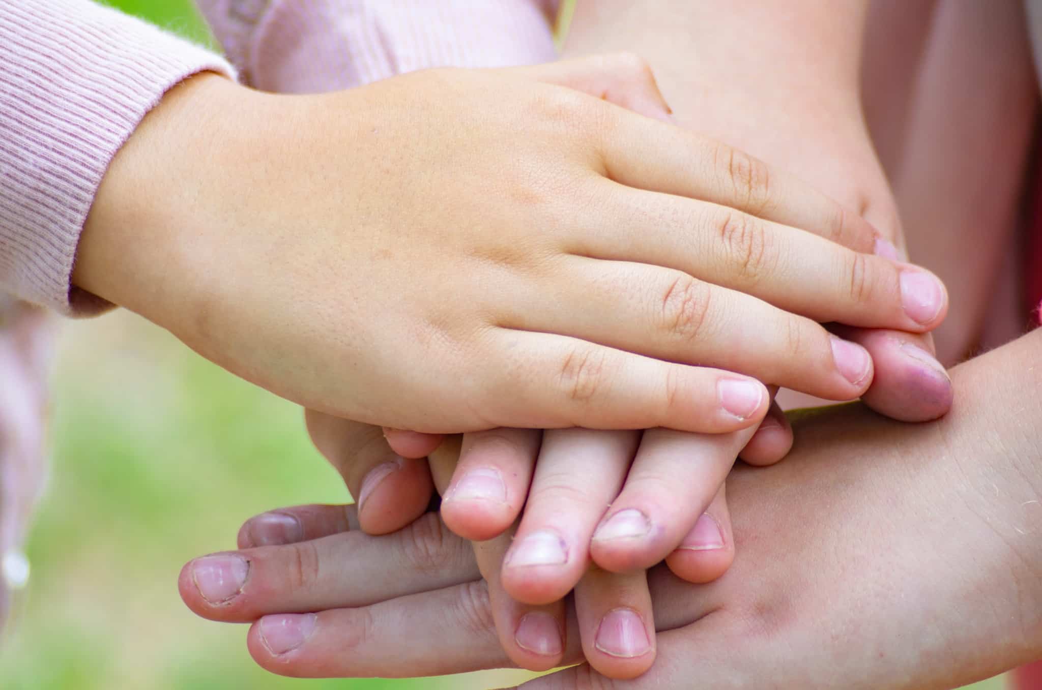 mãos de crianças, filhos que foram ensinados a ser solidários, sobrepostas e entrelaçadas