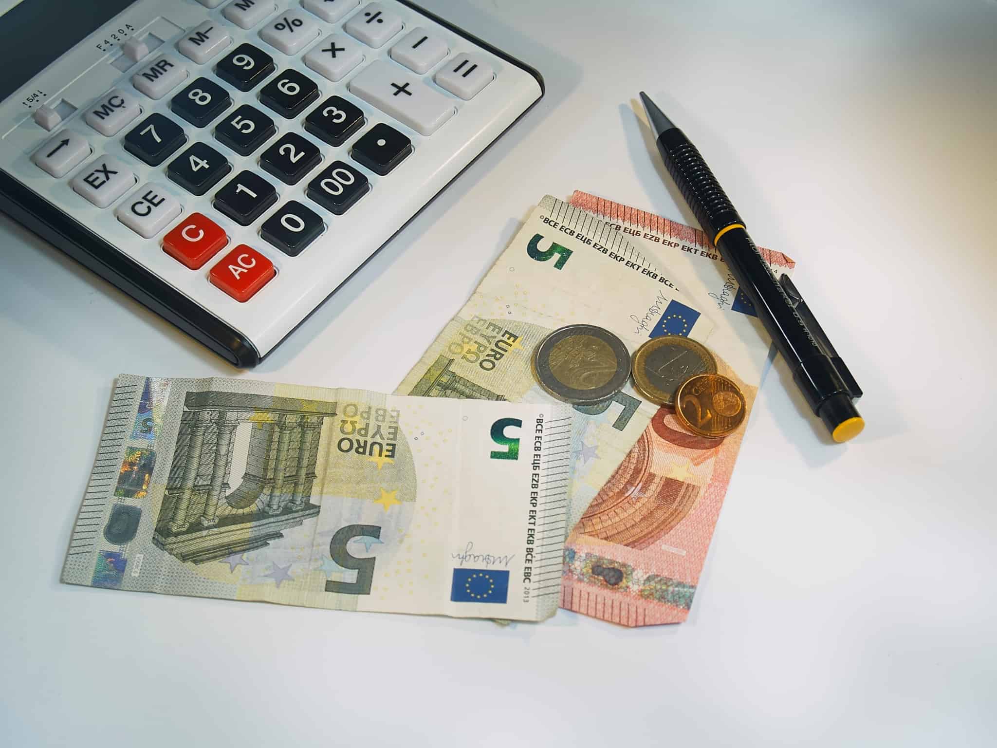 calculadora, notas e moedas de euro