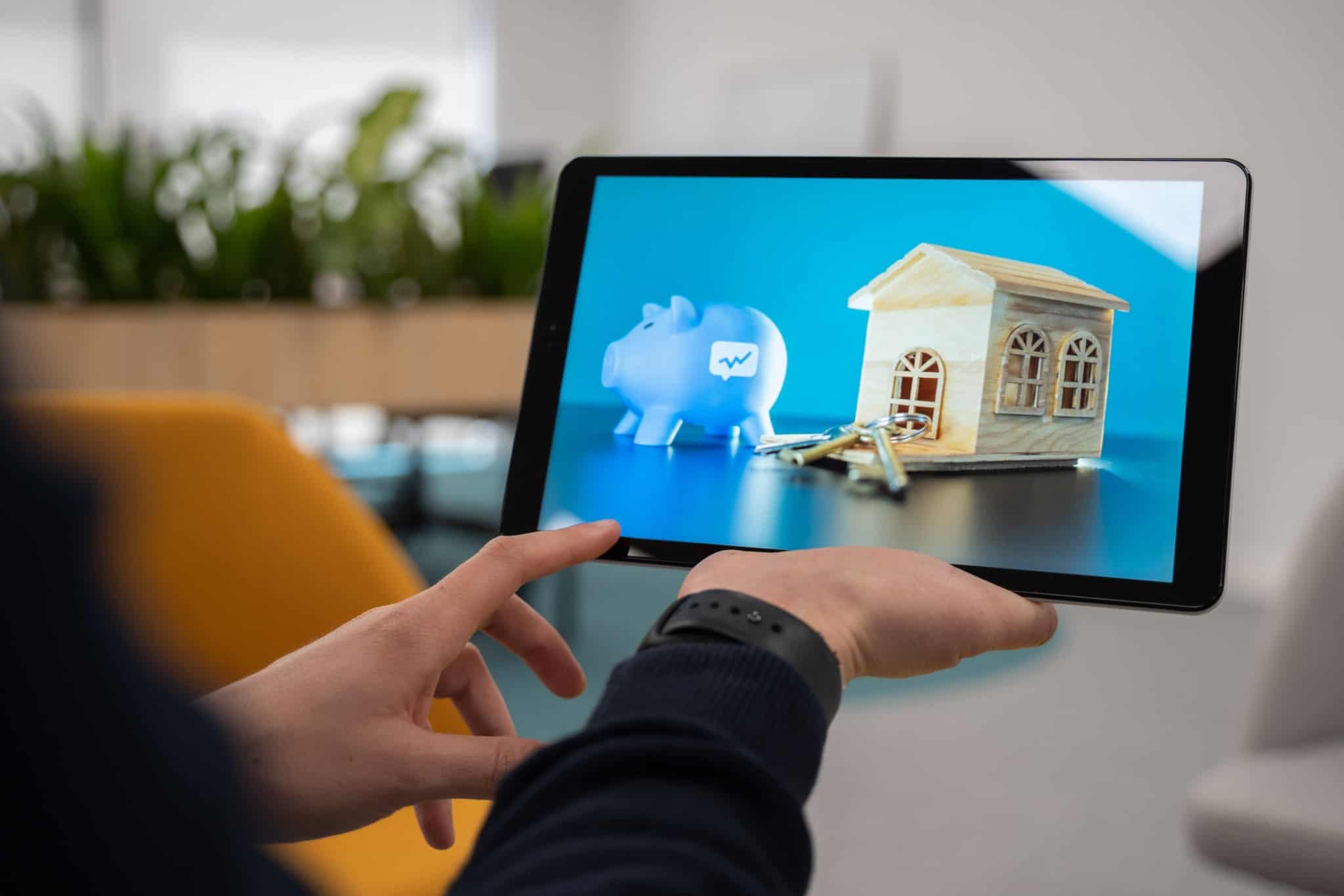 Jovem consulta o seu tablet à procura de indicadores sobre os preços das casas