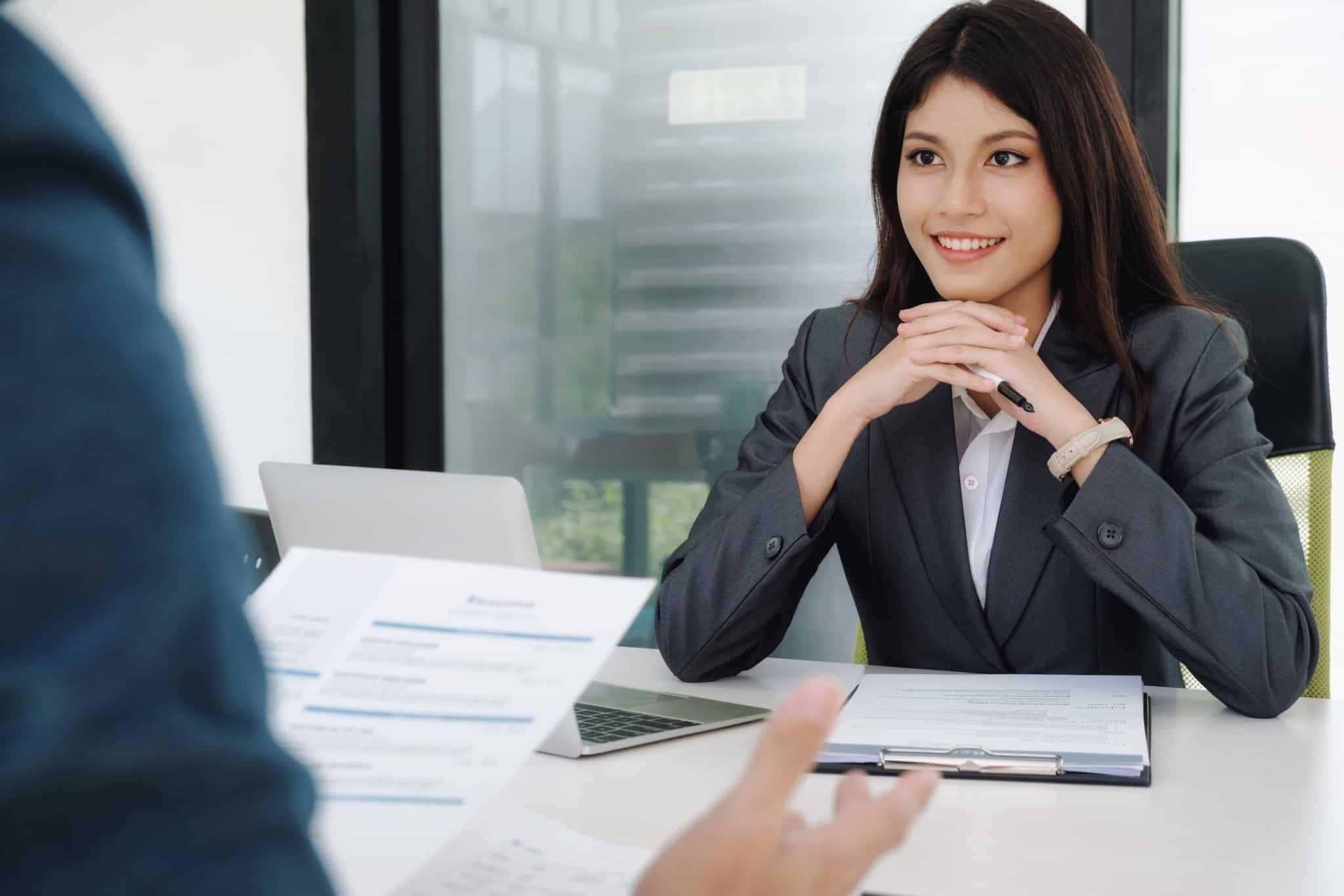 mulher sentada numa entrevista de trabalho antes de aceitar o primeiro emprego