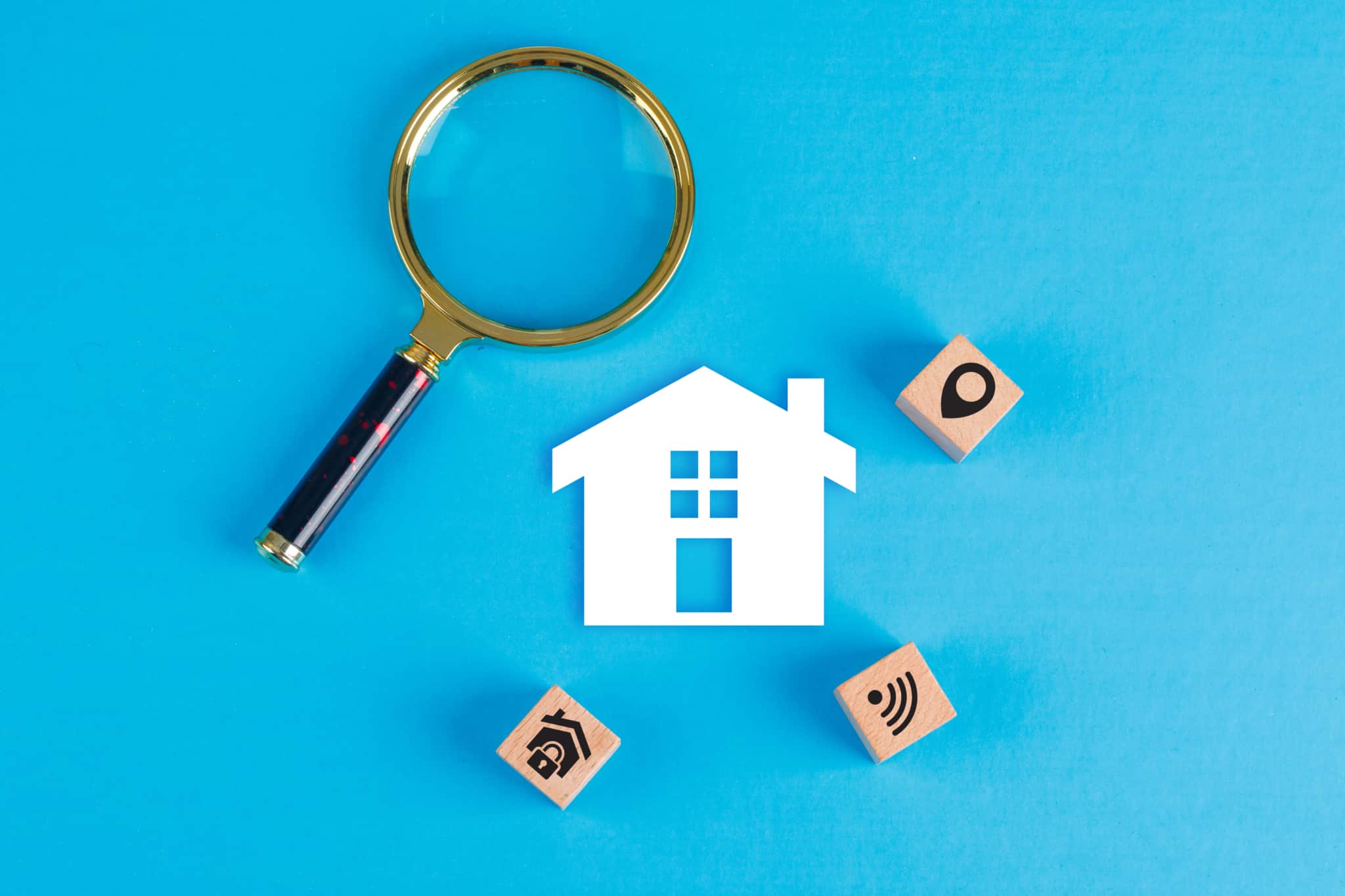 Fundo azul com uma casa branca e uma lupa para dar a resposta à questão se a minha primeira casa deve ser comprada ou arrendada
