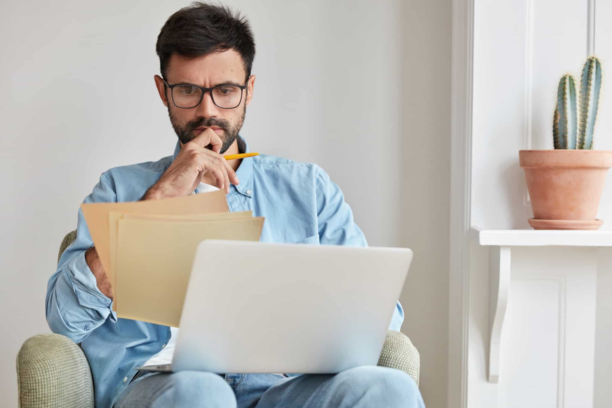 Homem sentado a segurar a analisar documentos as medidas do FMI para Portugal
