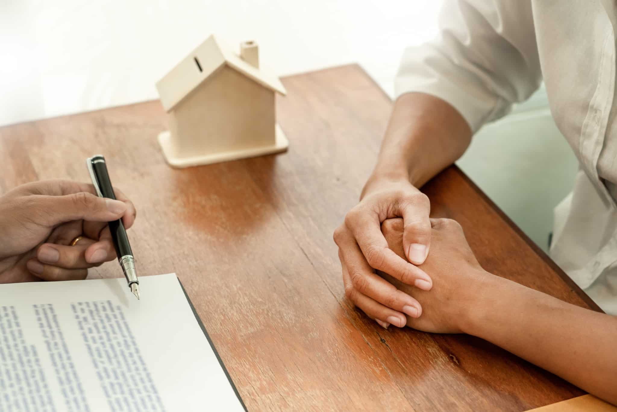 Imagem de duas pessoas a celebrar um contrato de crédito habitação - numa alusão à compra da primeira casa