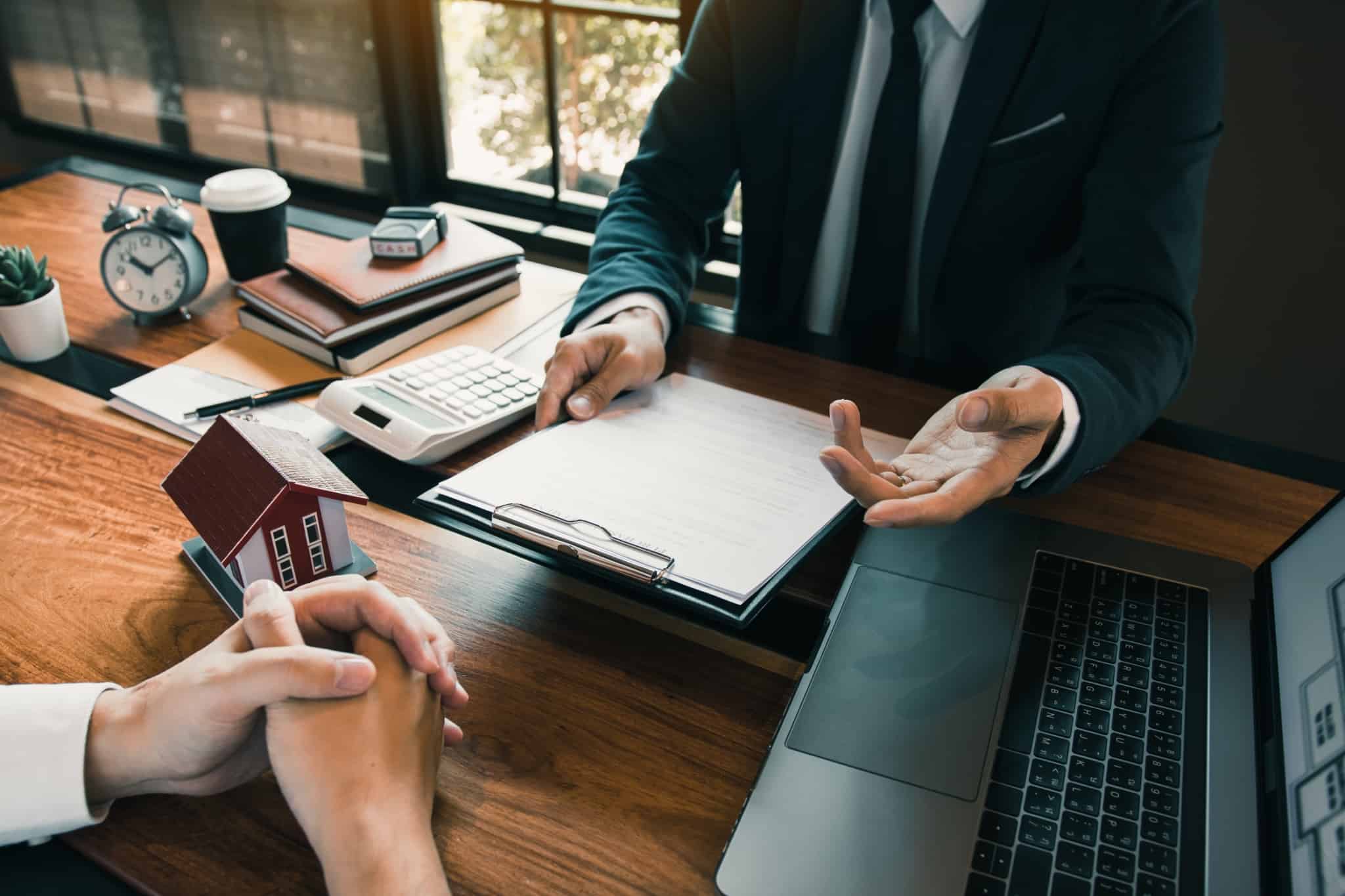 homens sentados à mesa analisam a FINE, a ficha que contém informação que deve guiar a compração de propostas dos bancos para crédito habitação