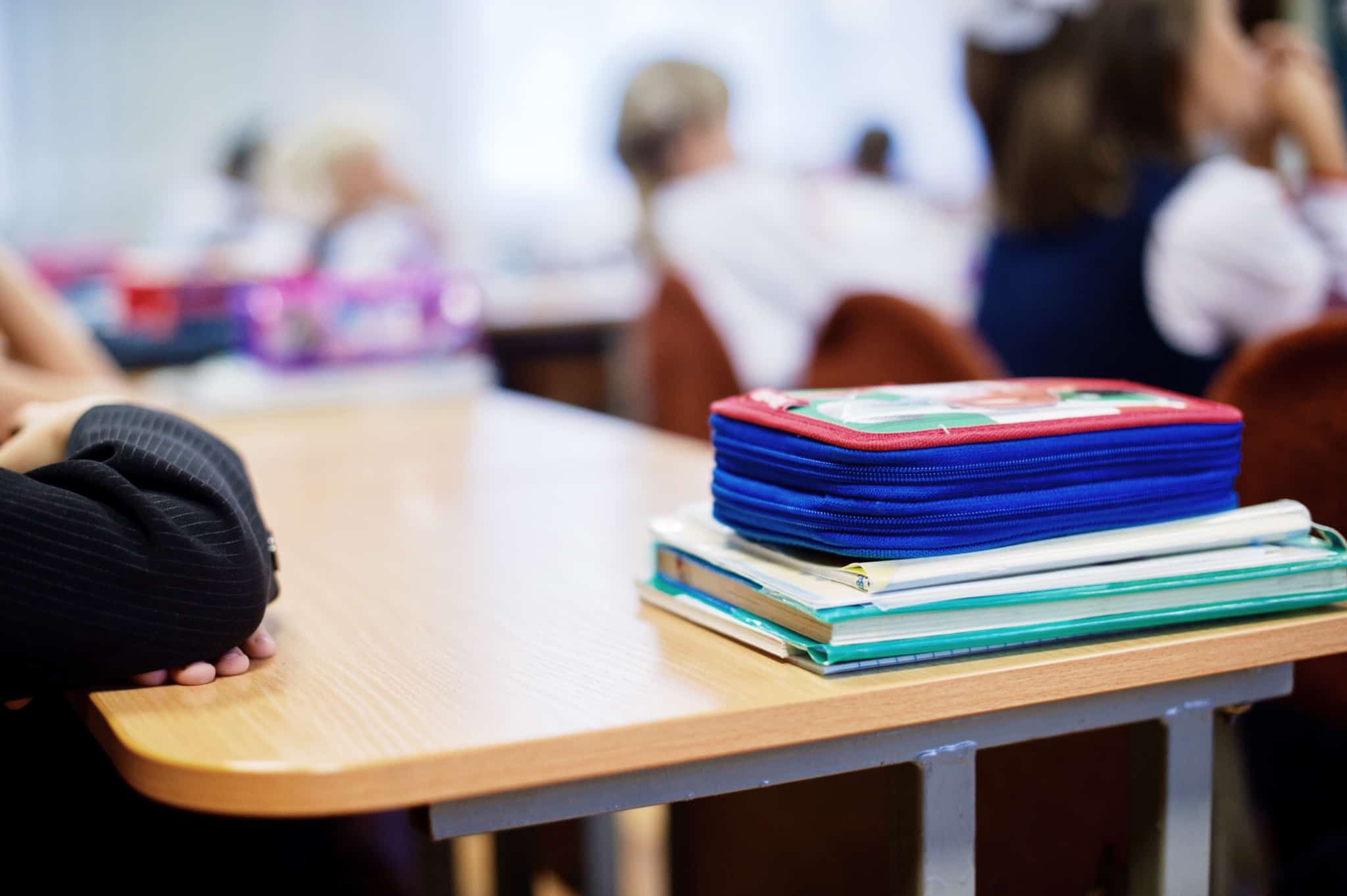Mesa em sala de aula com livros em cima